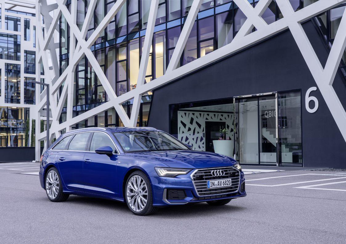 A blue Audi A6 Avant parked outside a building