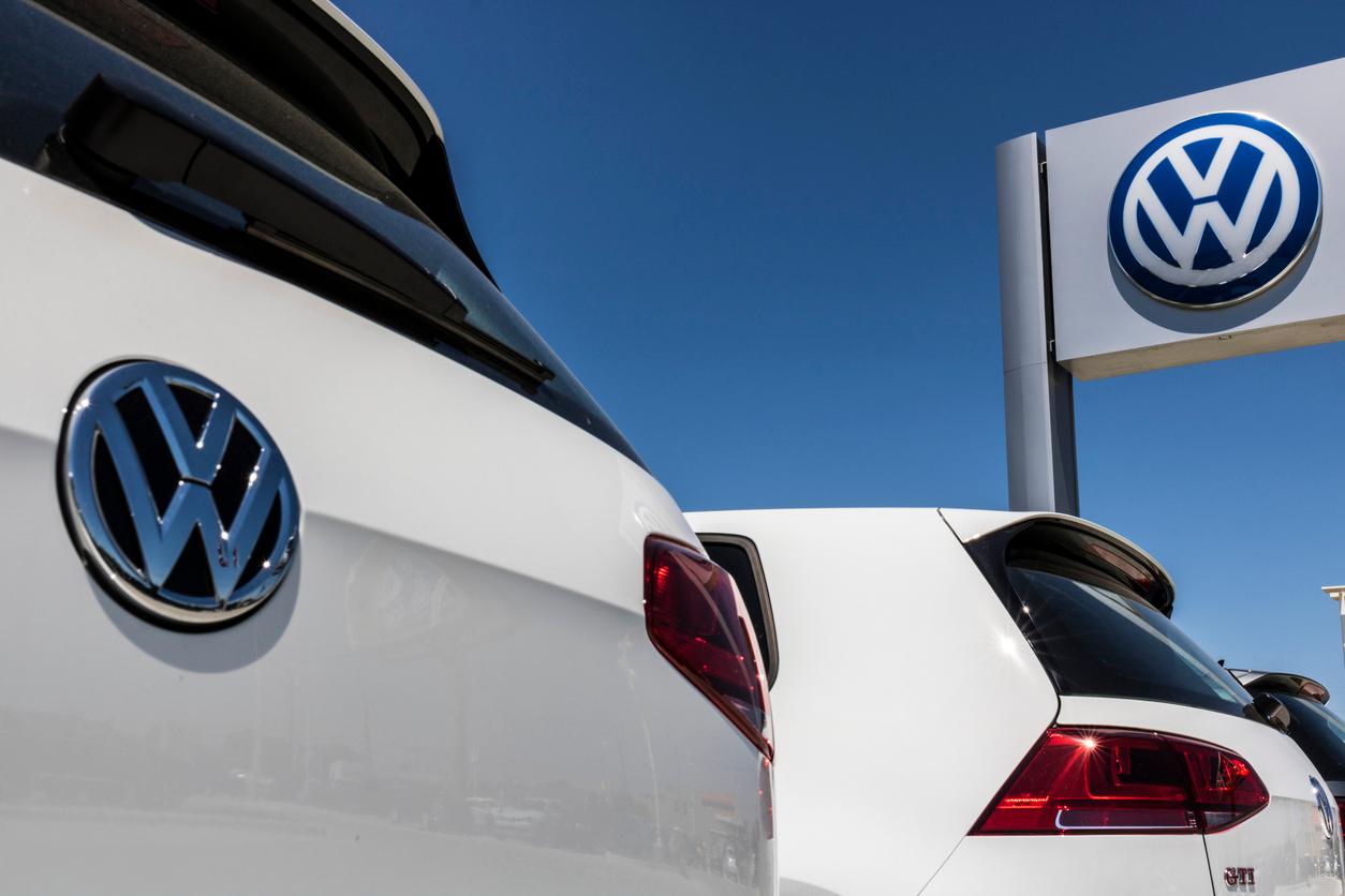 A close up on the VW logo on a car and sign