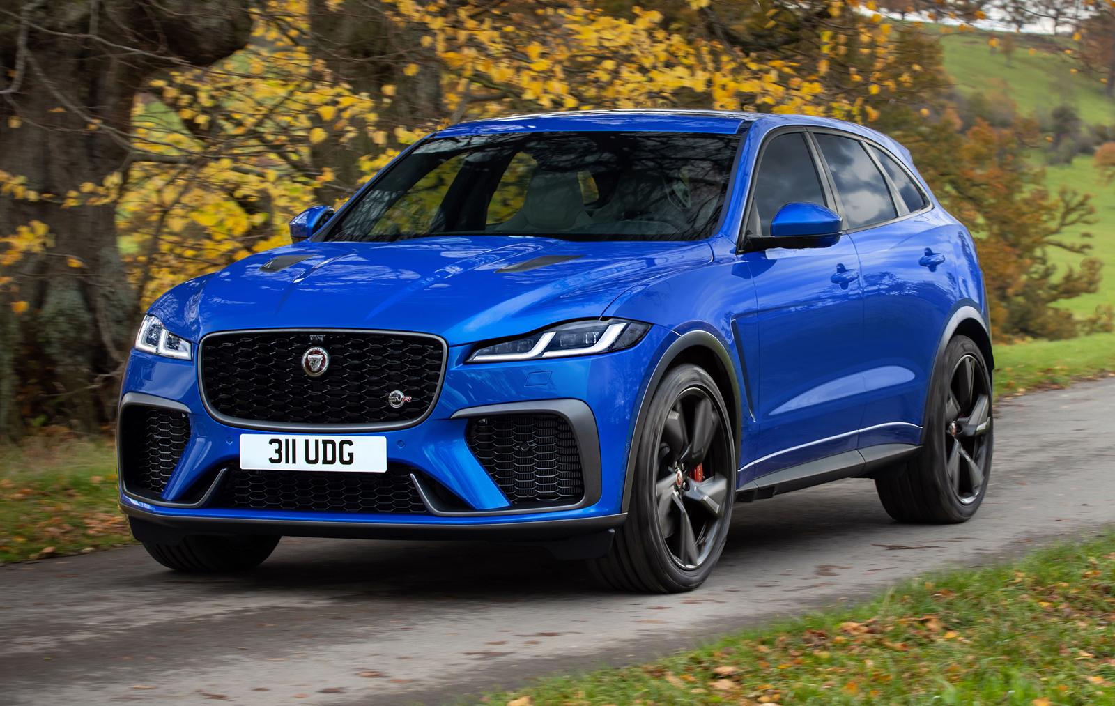 a blue Jaguar F-Pace SVR on a track surrounded by trees