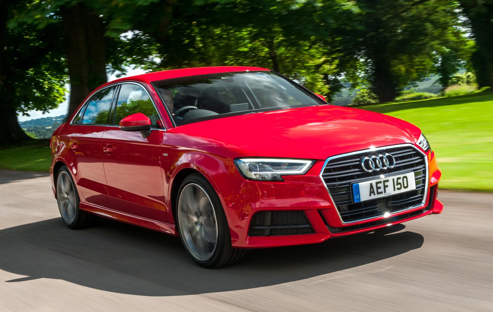 red audi a3 saloon driving on a road