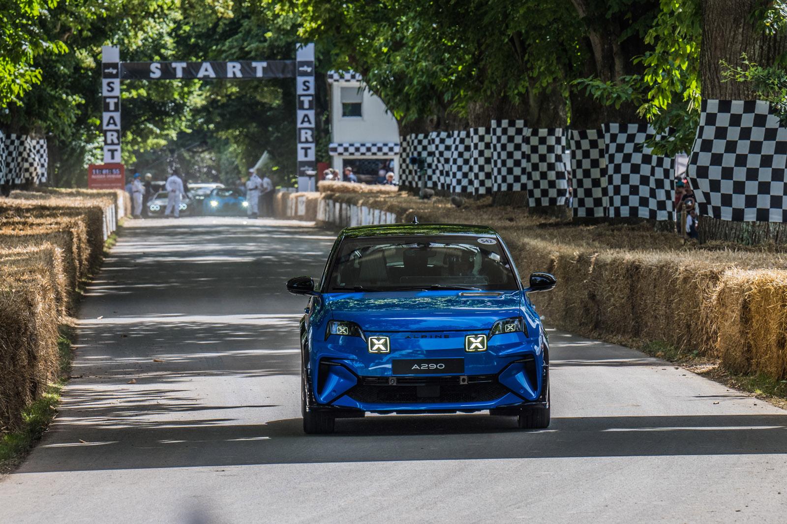 a dark blue alpine a290 driving up the goodwood hill climb