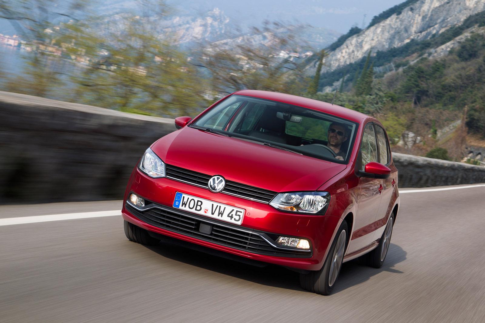 a red VW Polo fifth generation driving on a road