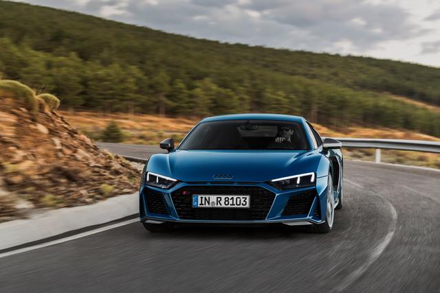 dark blue audi r8 driving on a mountain road