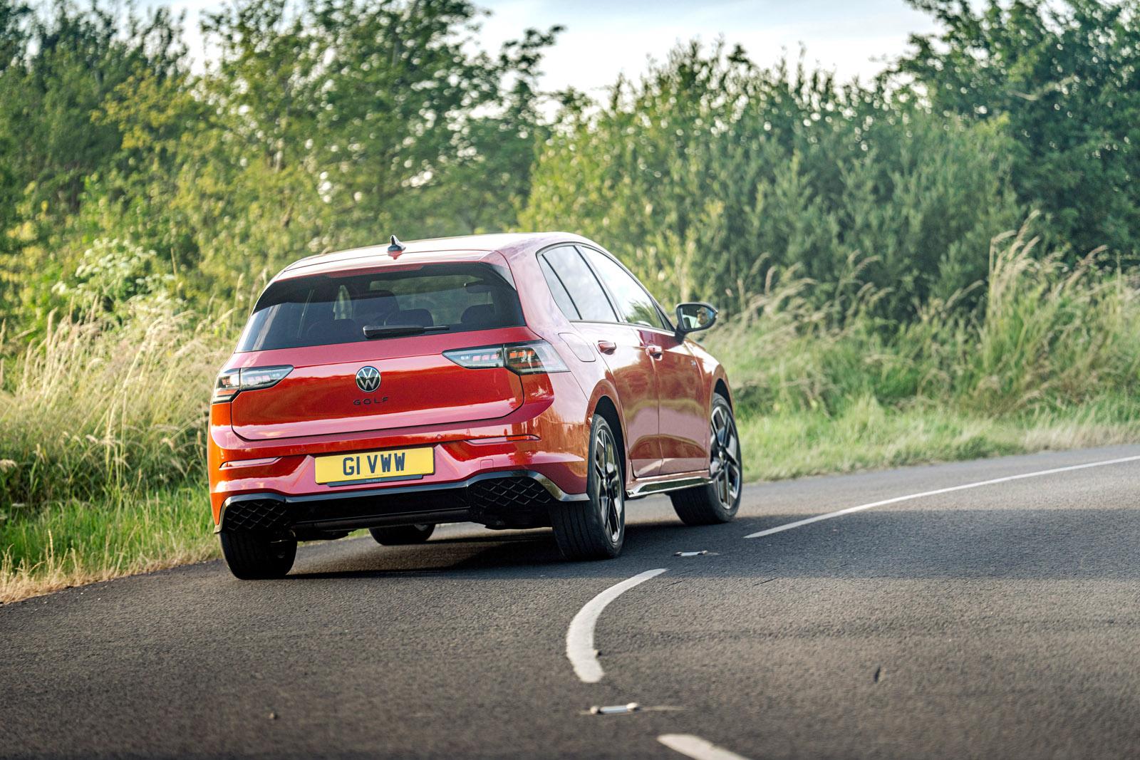 a red vw golf cornering on a country road in the uk