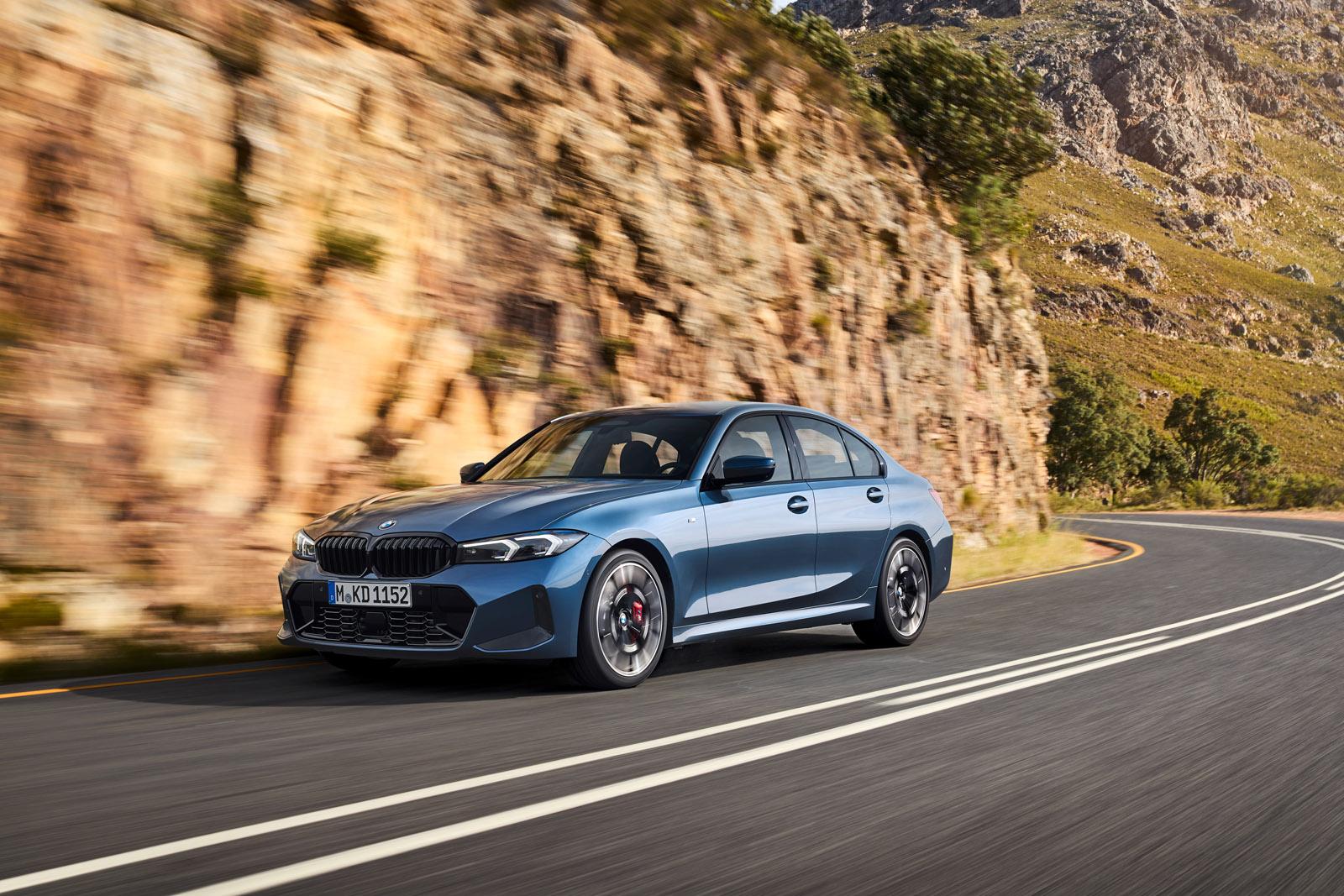 a dark blue BMW 3 Series driving on a mountain road