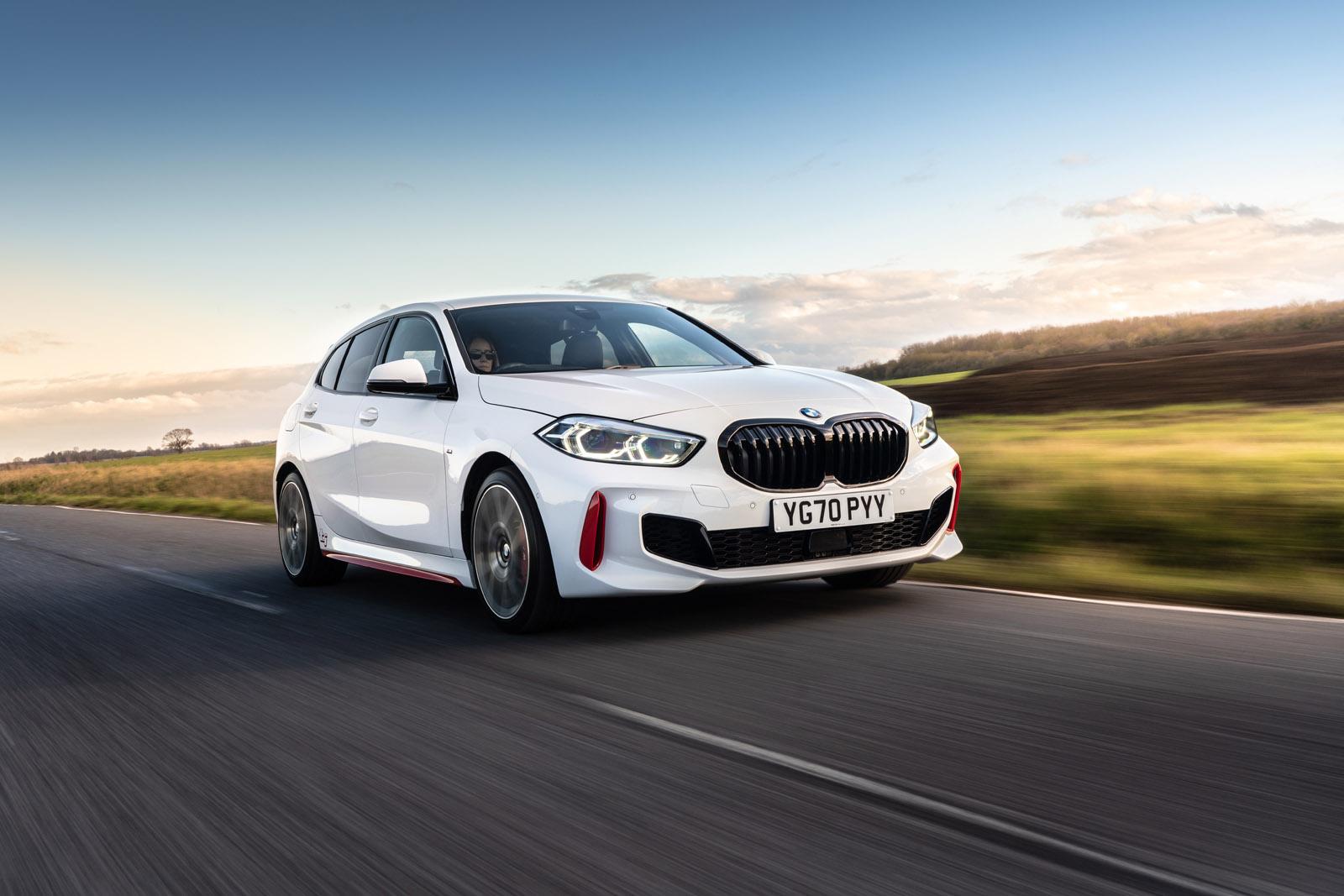 a white bmw 128ti driving on a country road