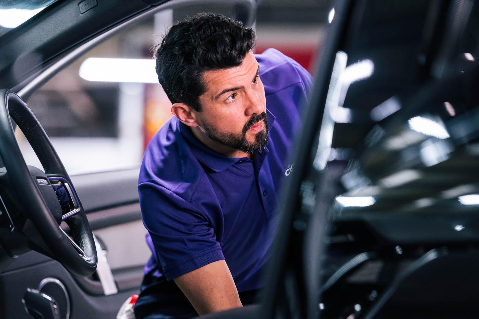 Mechanic checking interior of car during service