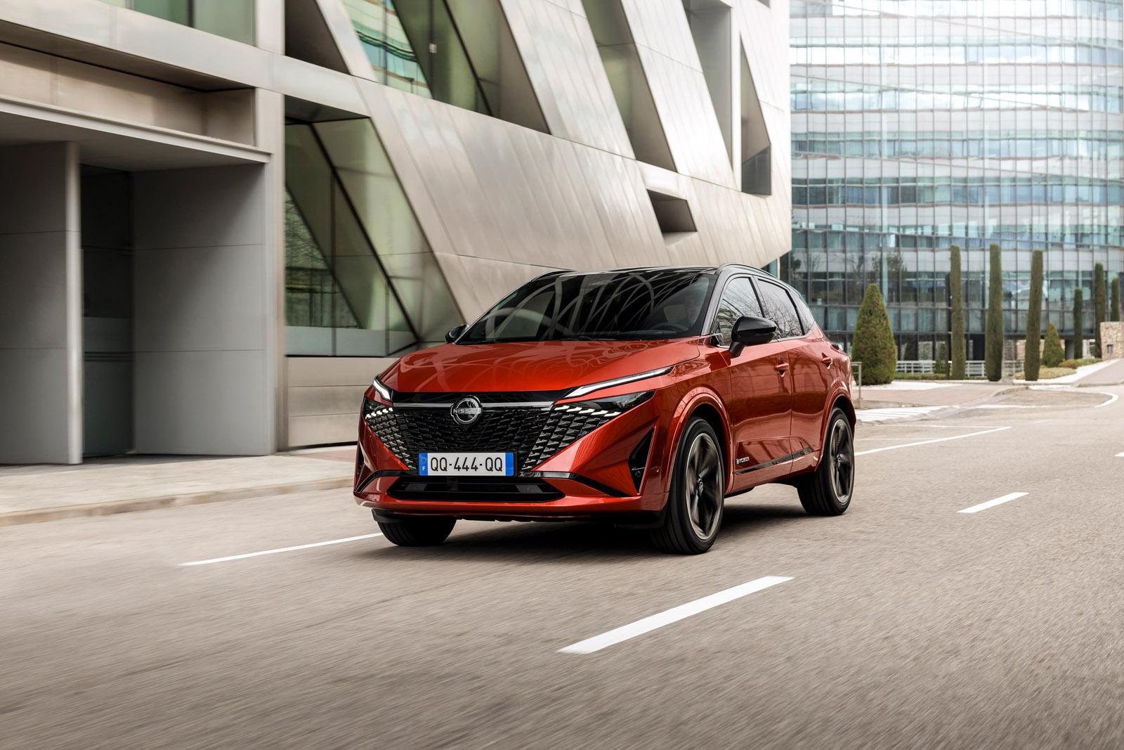 a red 2024 nissan qashqai driving on a road