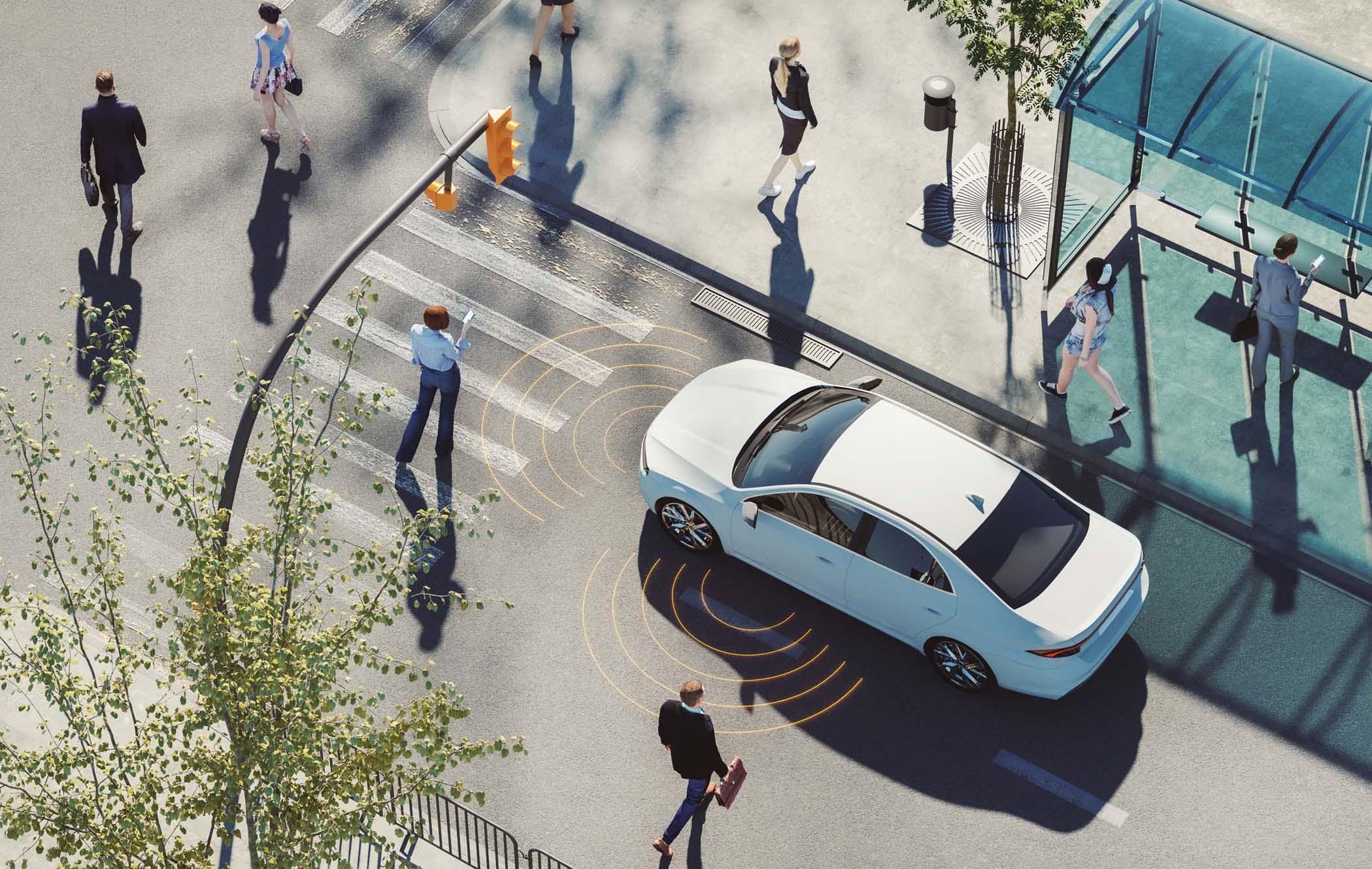 Aerial view of a white car at a crosswalk, surrounded by pedestrians and safety sensors, near a modern bus stop on a sunny day.