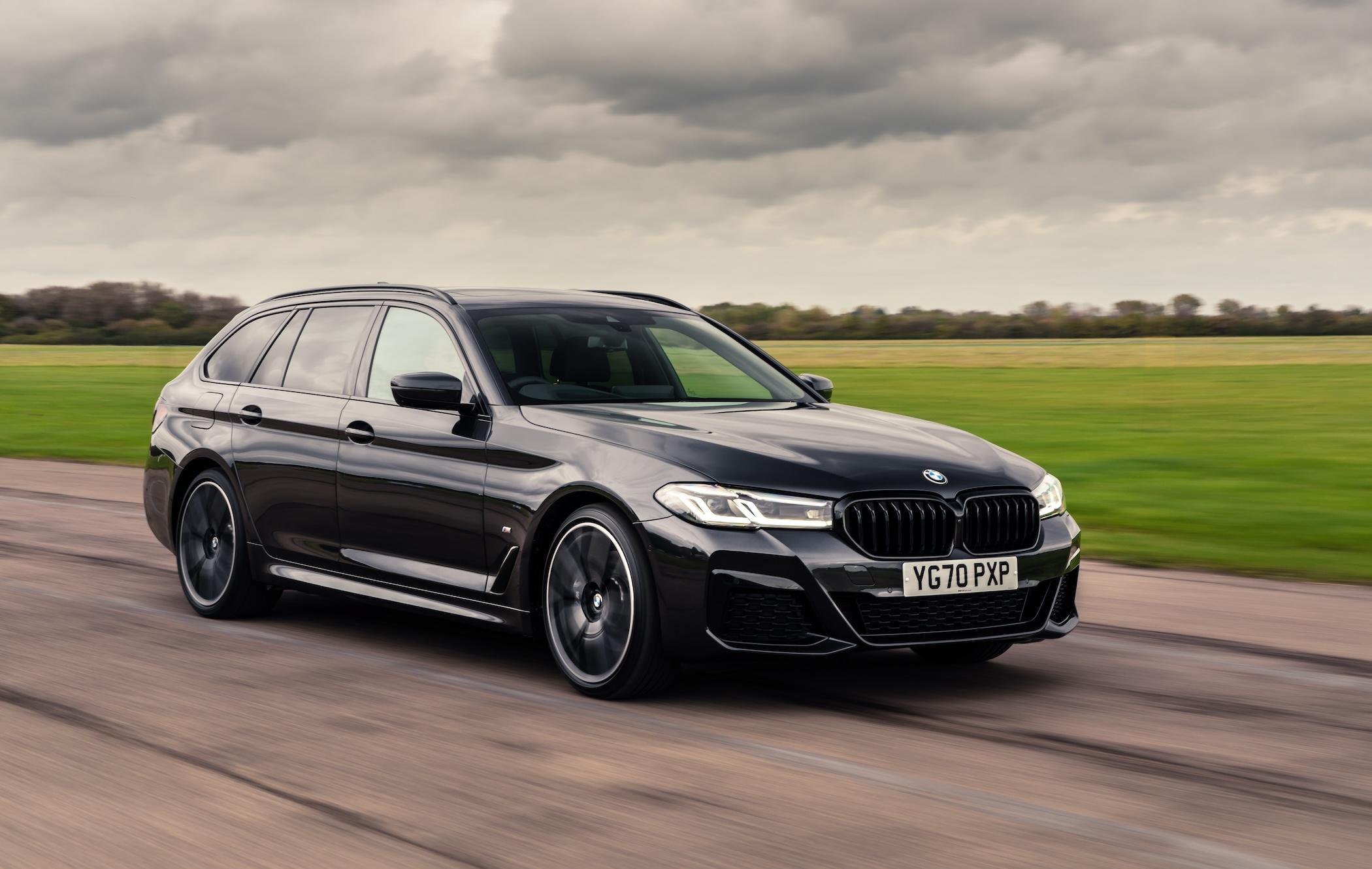 Black BMW 5 Series Touring driving along road