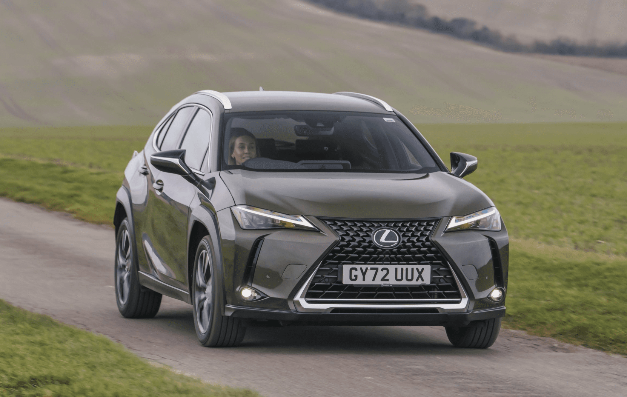 Dark green Lexus UX driving on lane