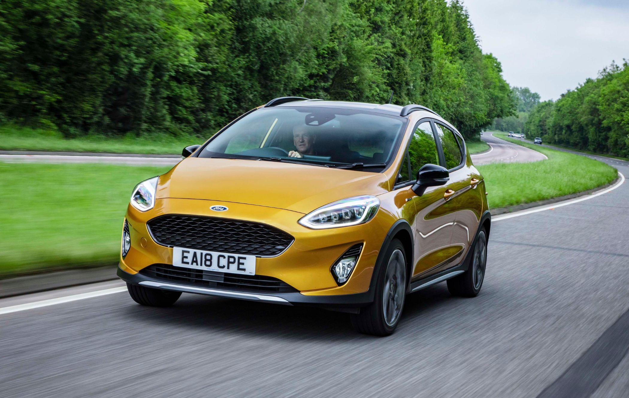 Yellow Ford Fiesta Active driving on country road