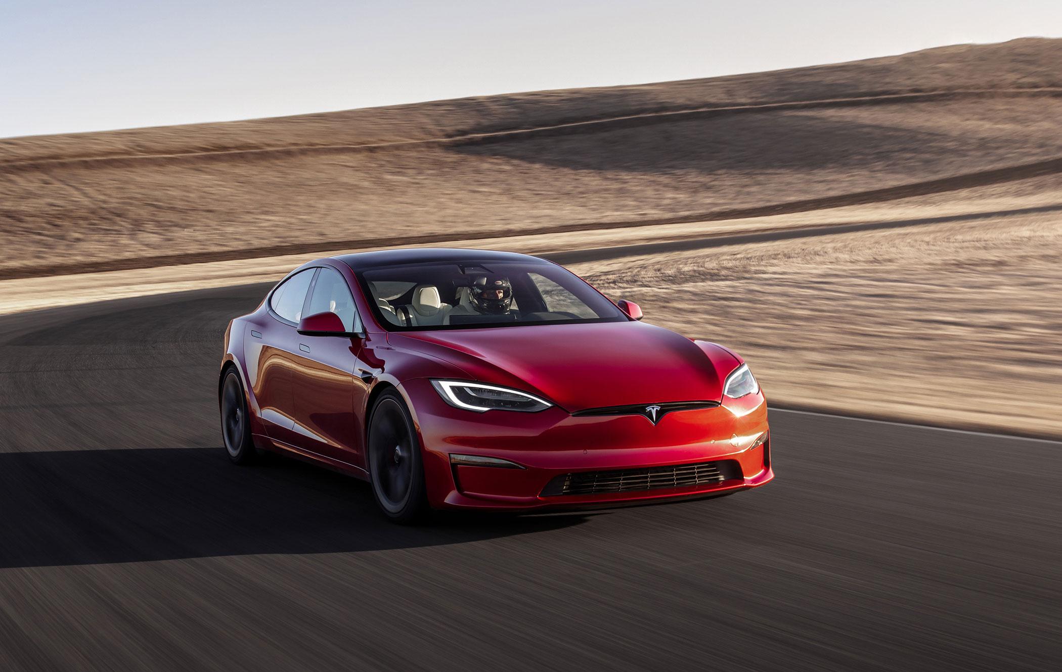 a red tesla model s plaid driving on a racetrack in the American desert