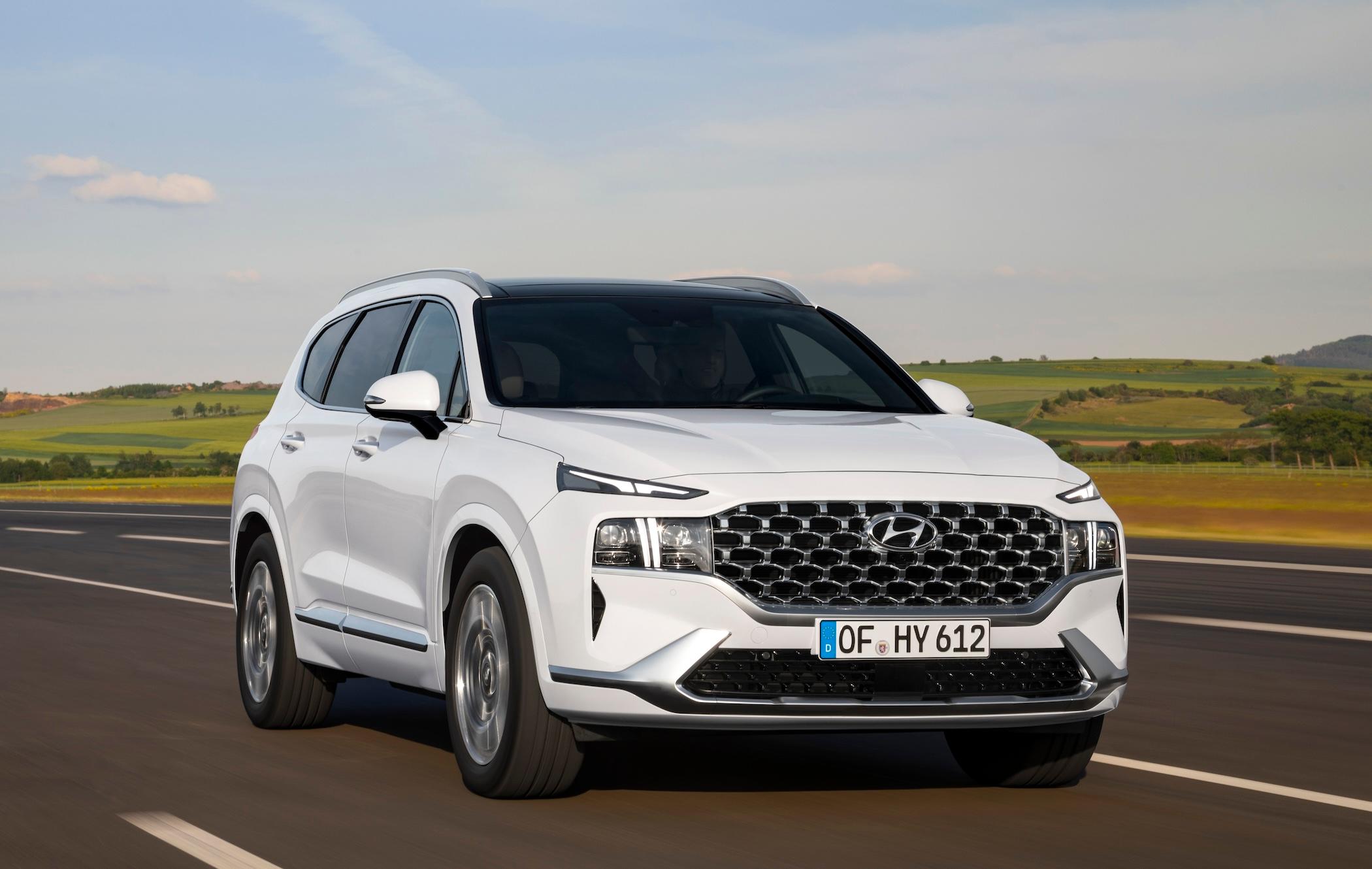 Front three-quarters view of white Hyundai Santa Fe driving, pictures on German number plates