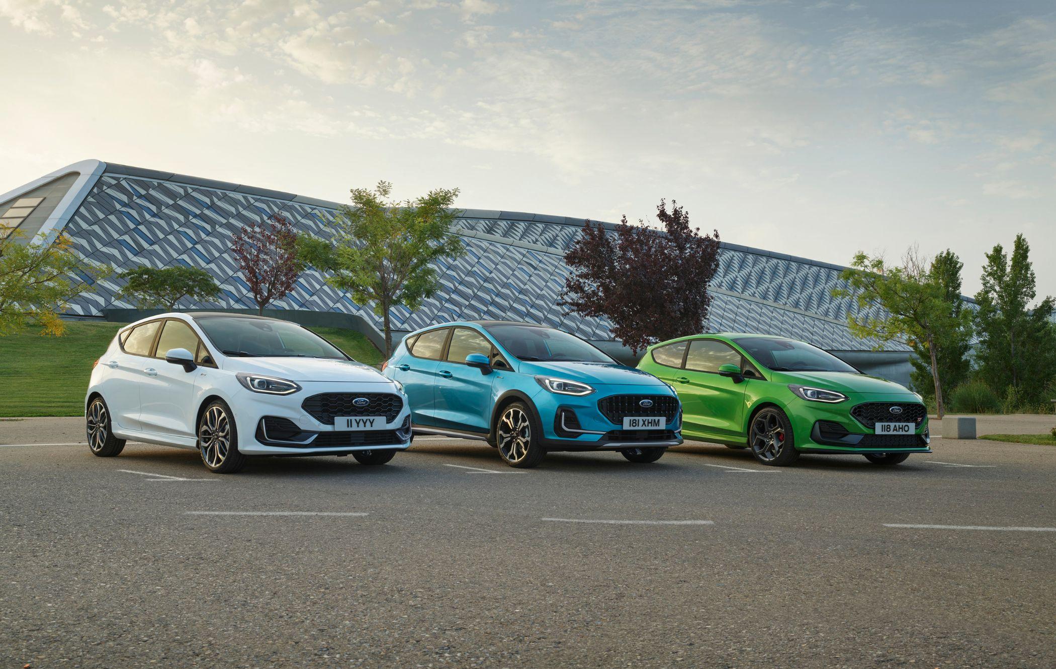 White Ford Fiesta, blue Ford Fiesta Active, and green Ford Fiesta ST parked in a row