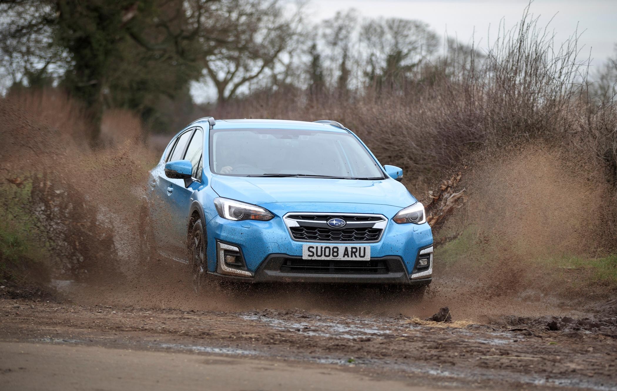 Blue Subaru XV splashing through mud