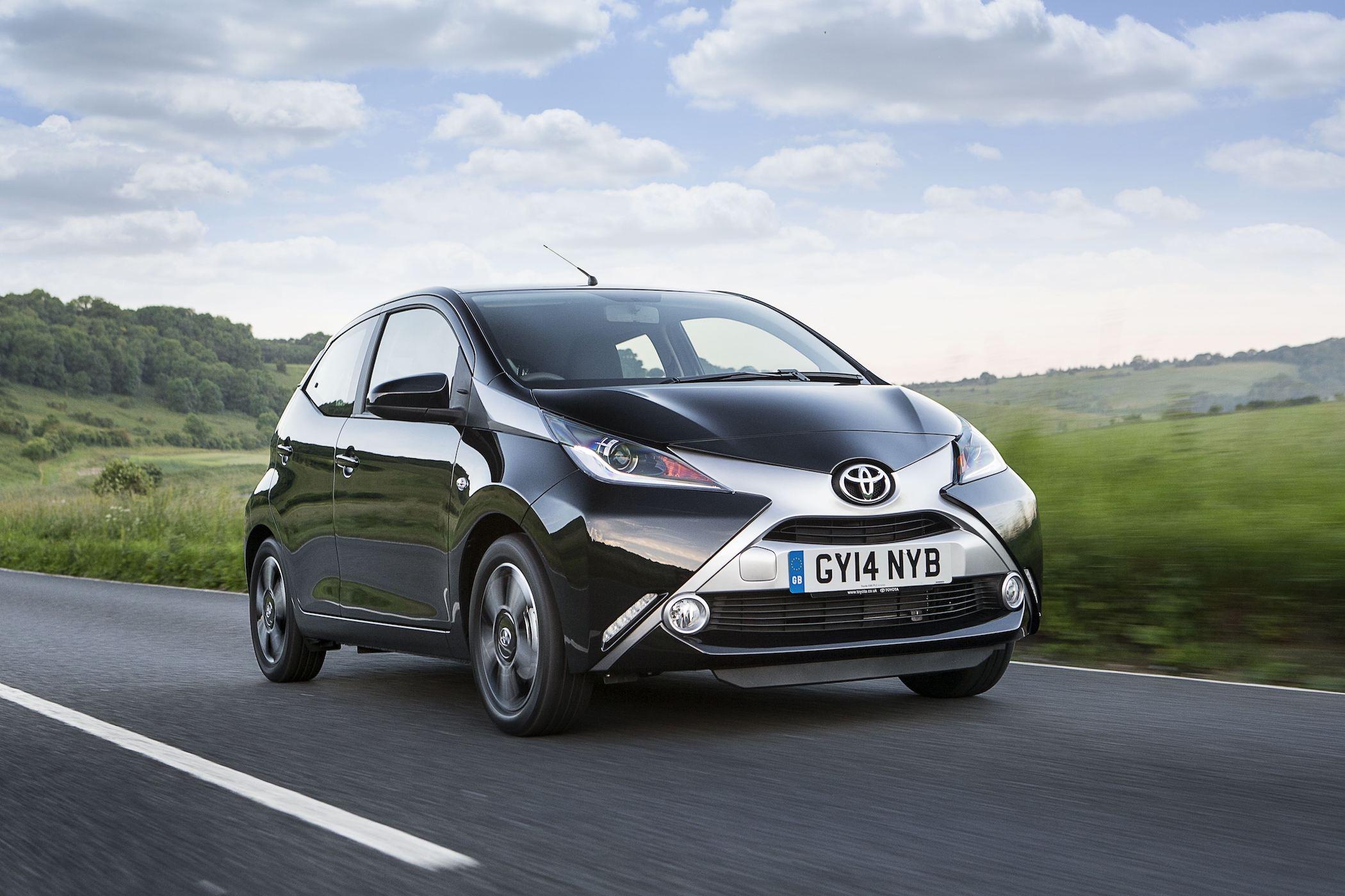 a black toyota aygo driving on a road