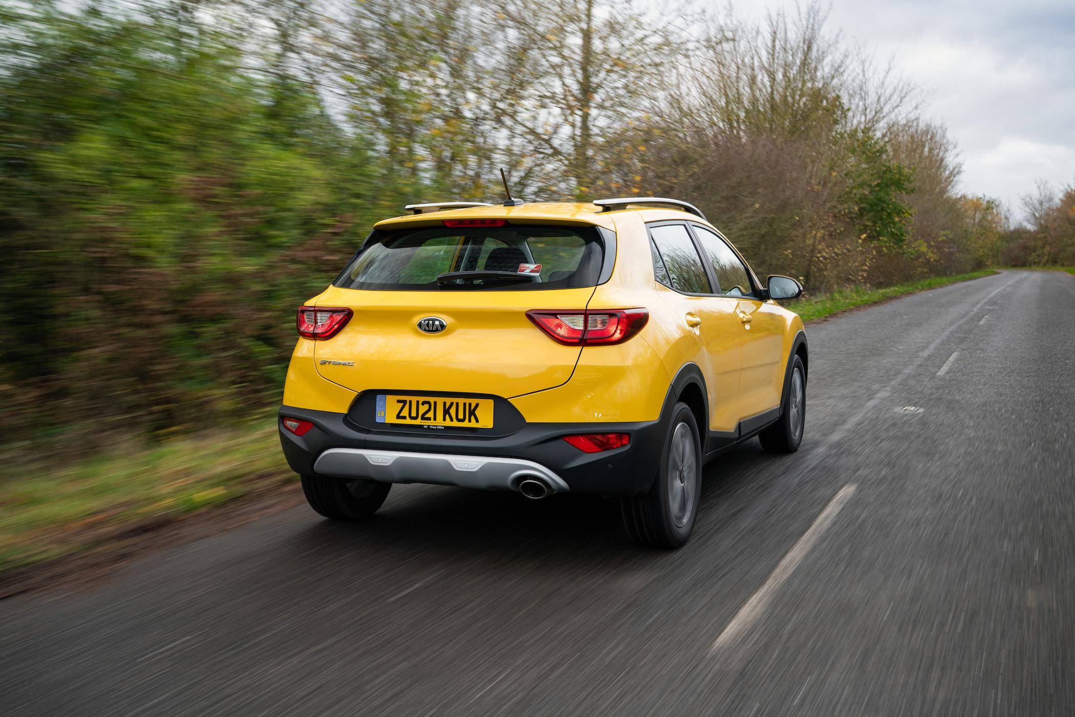 a yellow kia stonic driving on the road