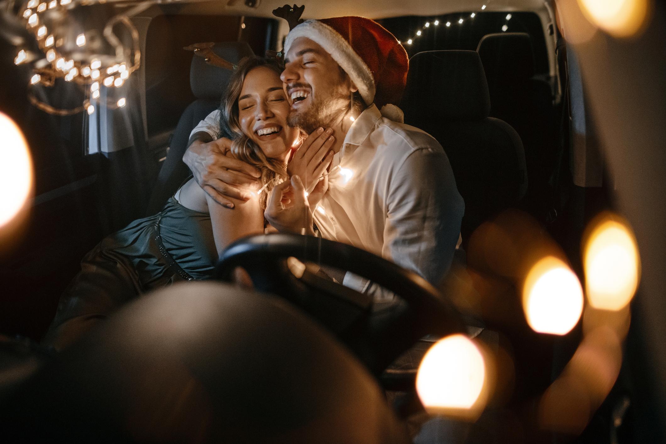 A man and a woman singing and smiling in a car