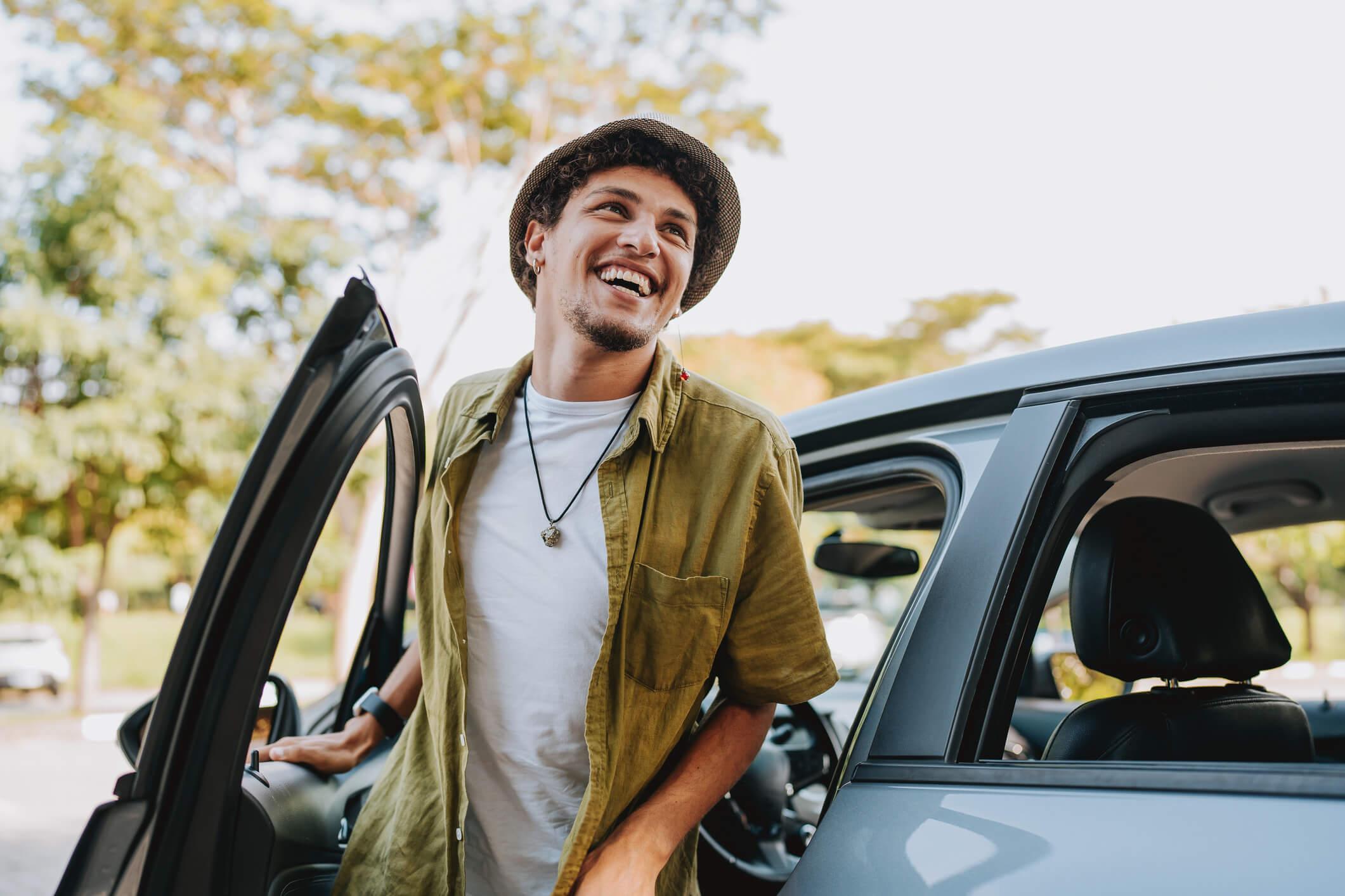 A smiling man getting out of a car