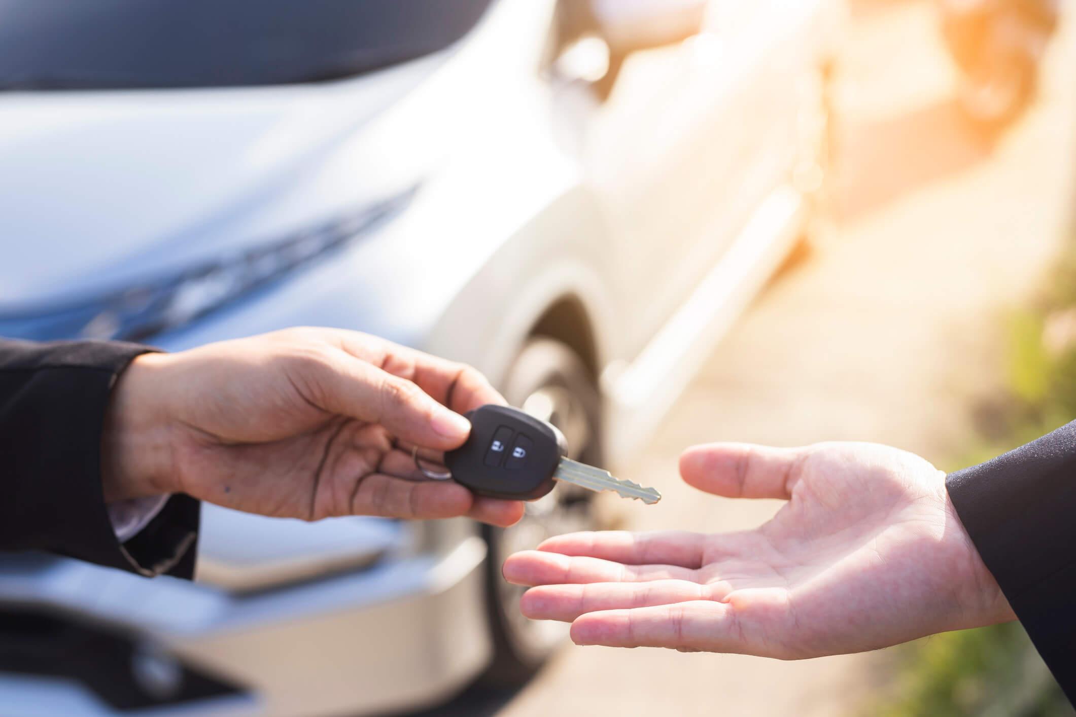 Two hands exchanging a car key