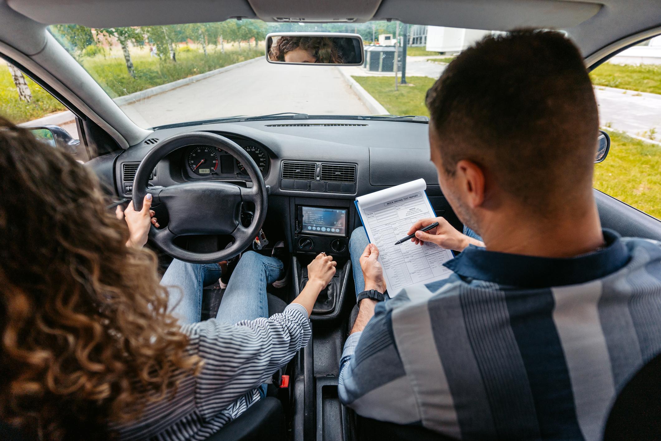 Two people carrying out a car driving test