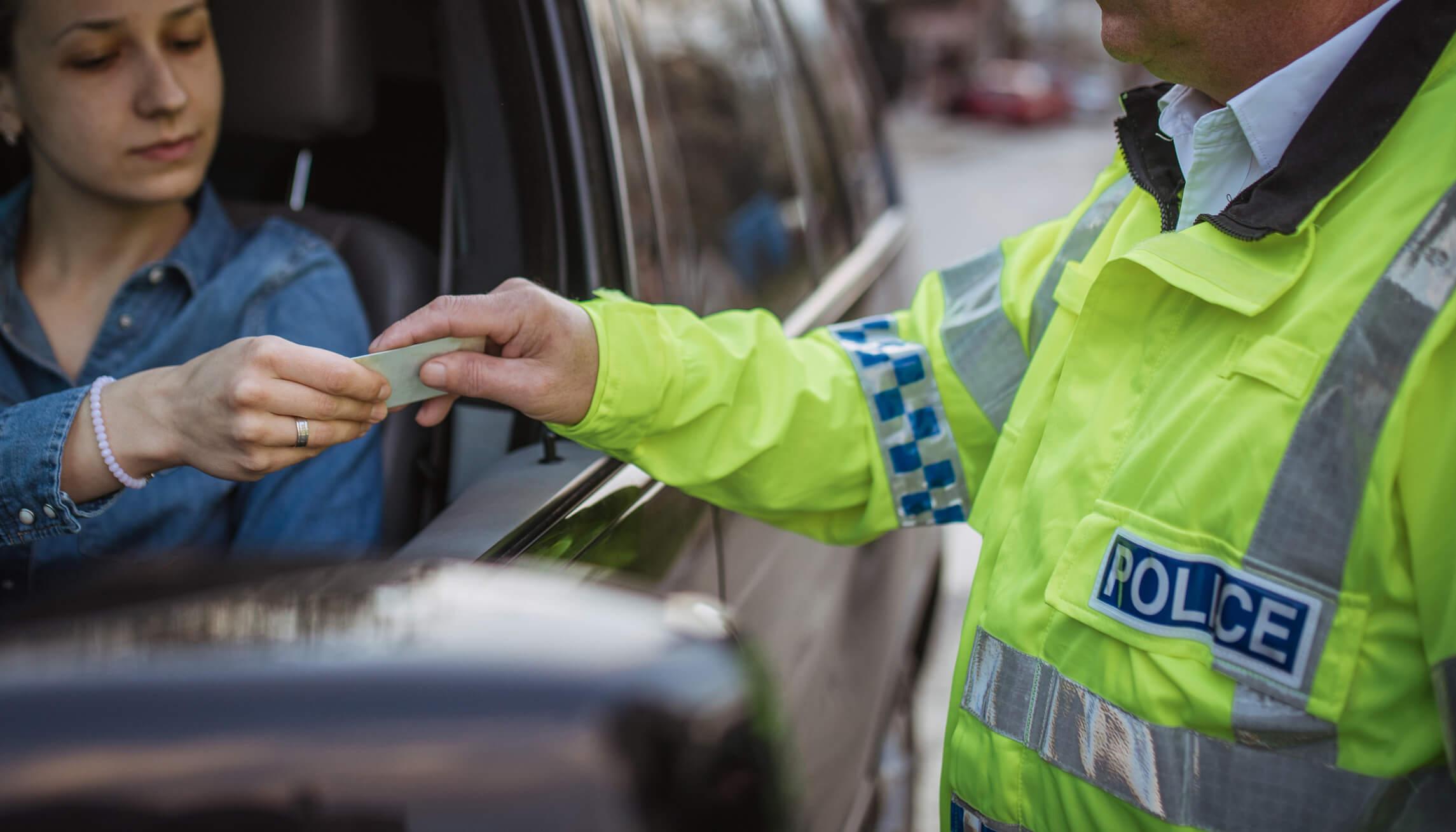 A police officer inspecting a driving licence