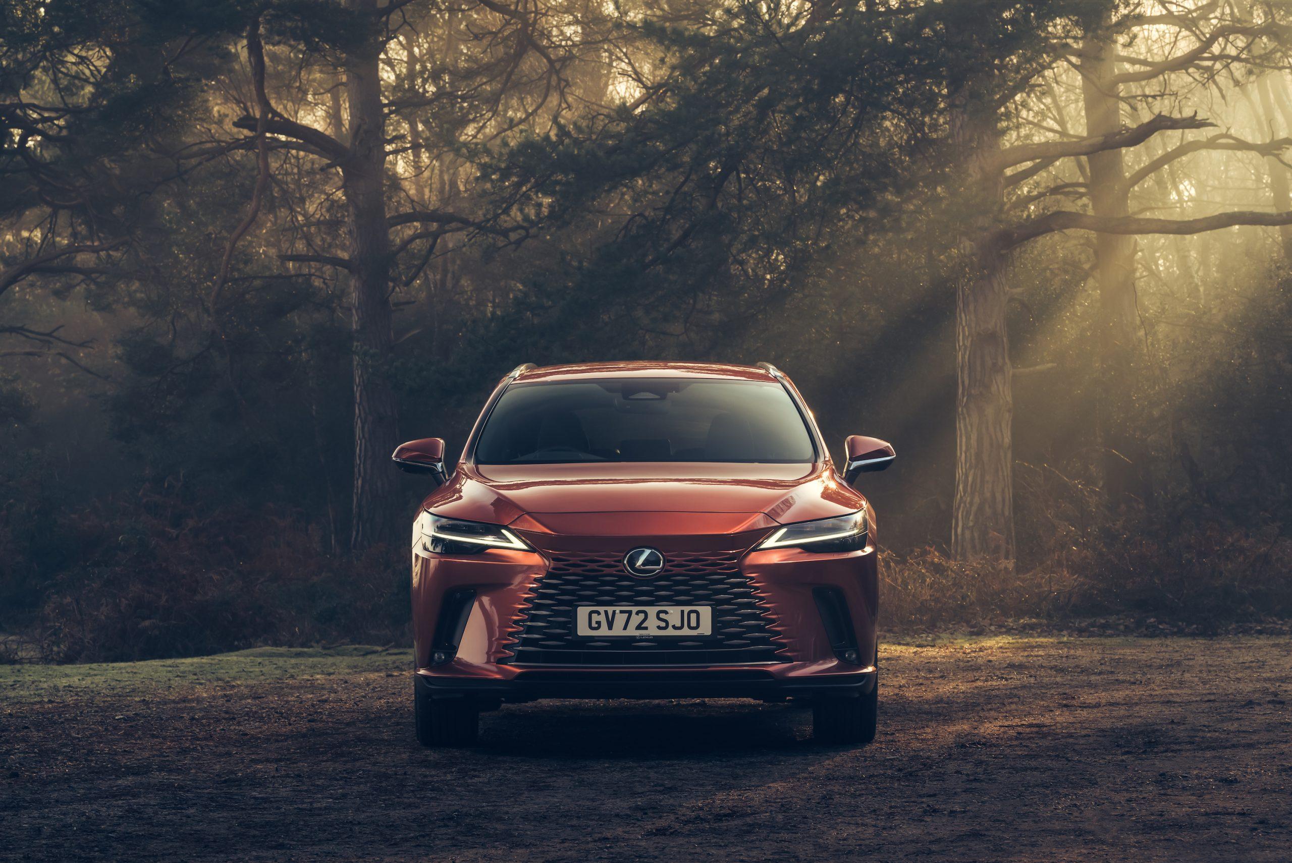 an orange Lexus RX parked in a forest