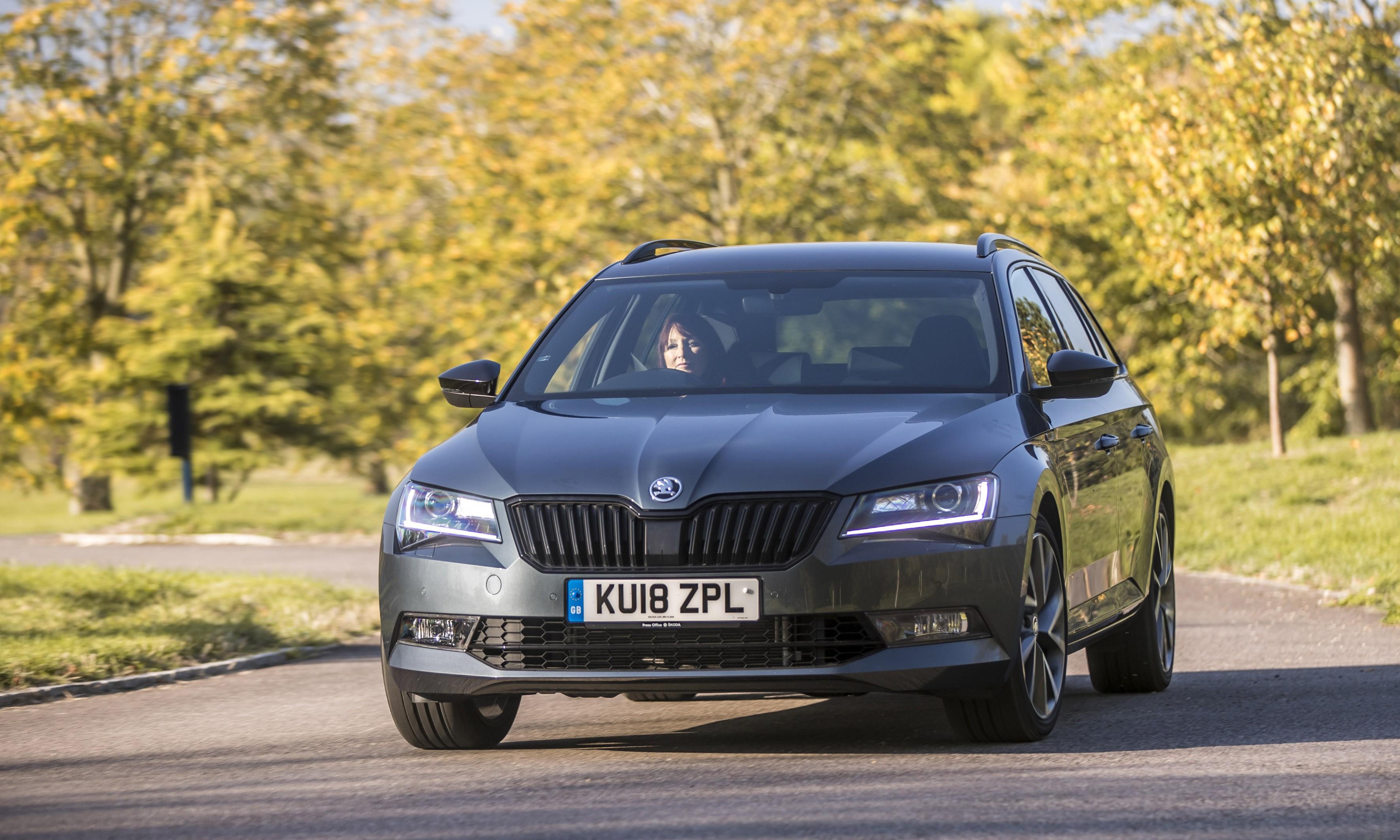 A grey Skoda Superb driving on a country road