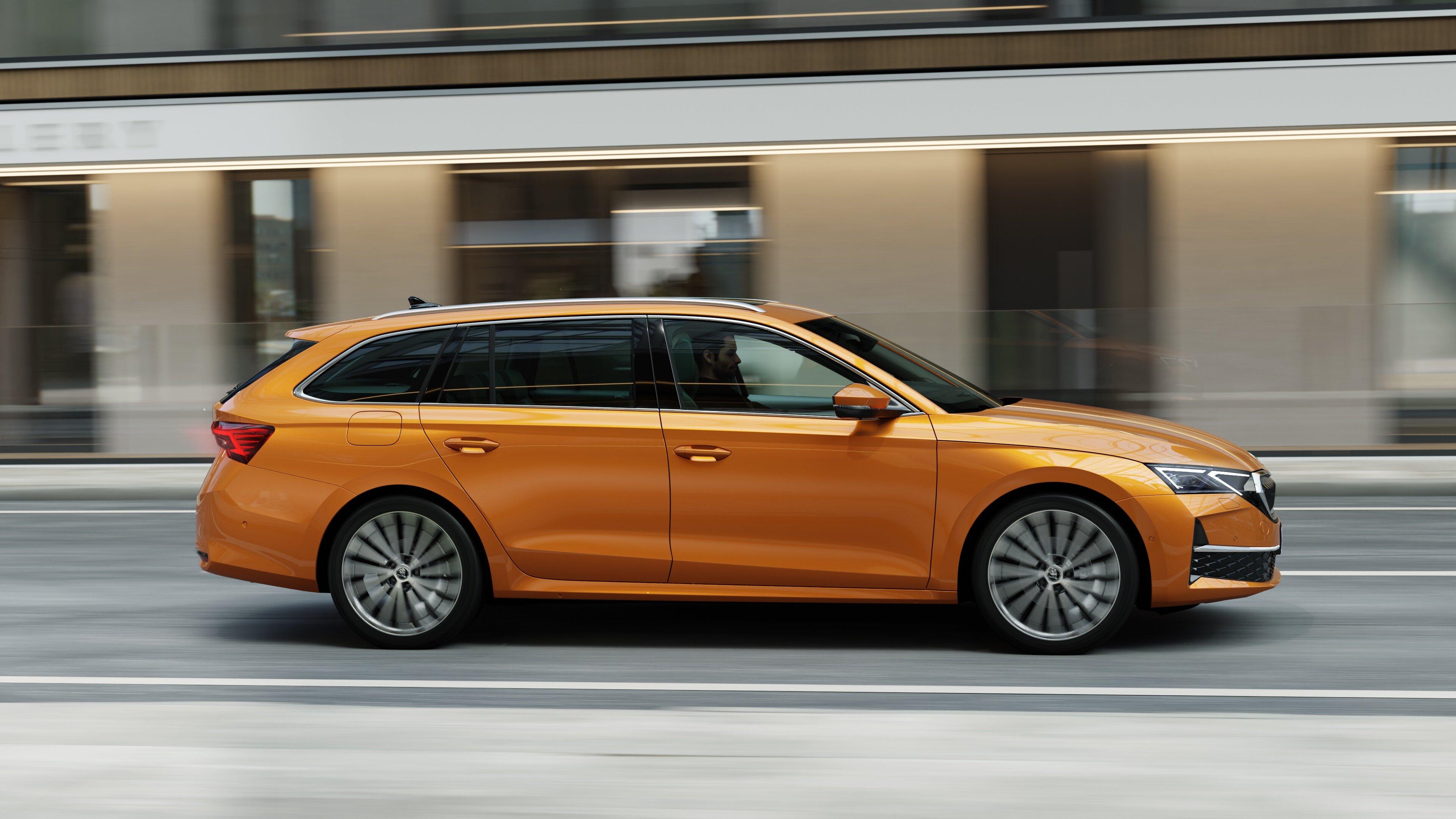 an orange skoda octavia estate driving on a road