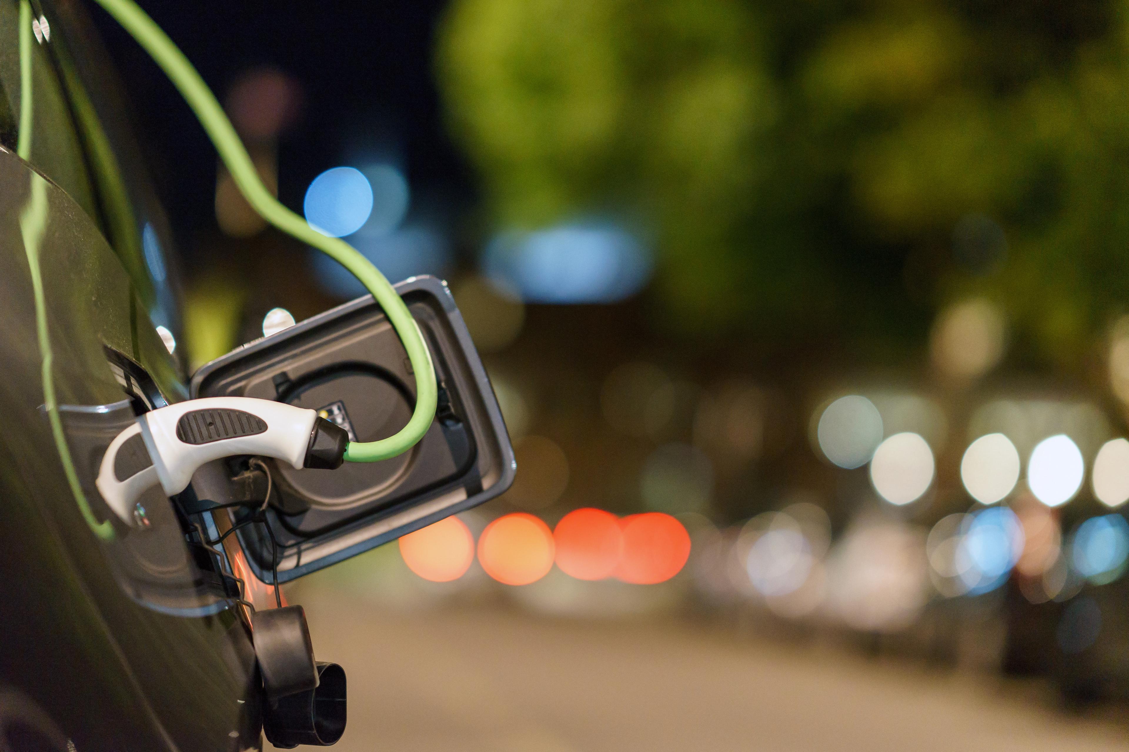 an electric car charging on the side of the road at night