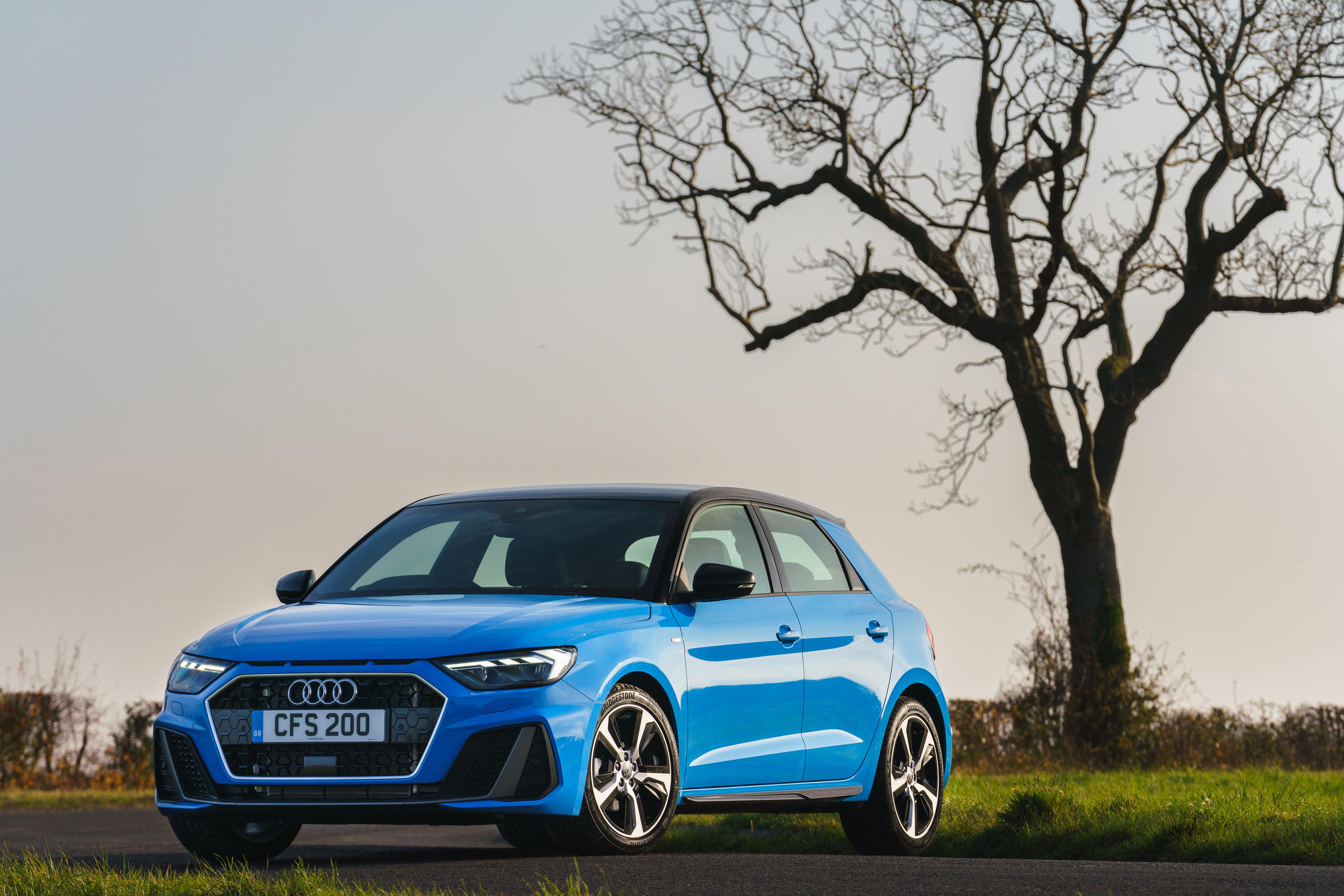 A blue Audi A1 parked under a tree