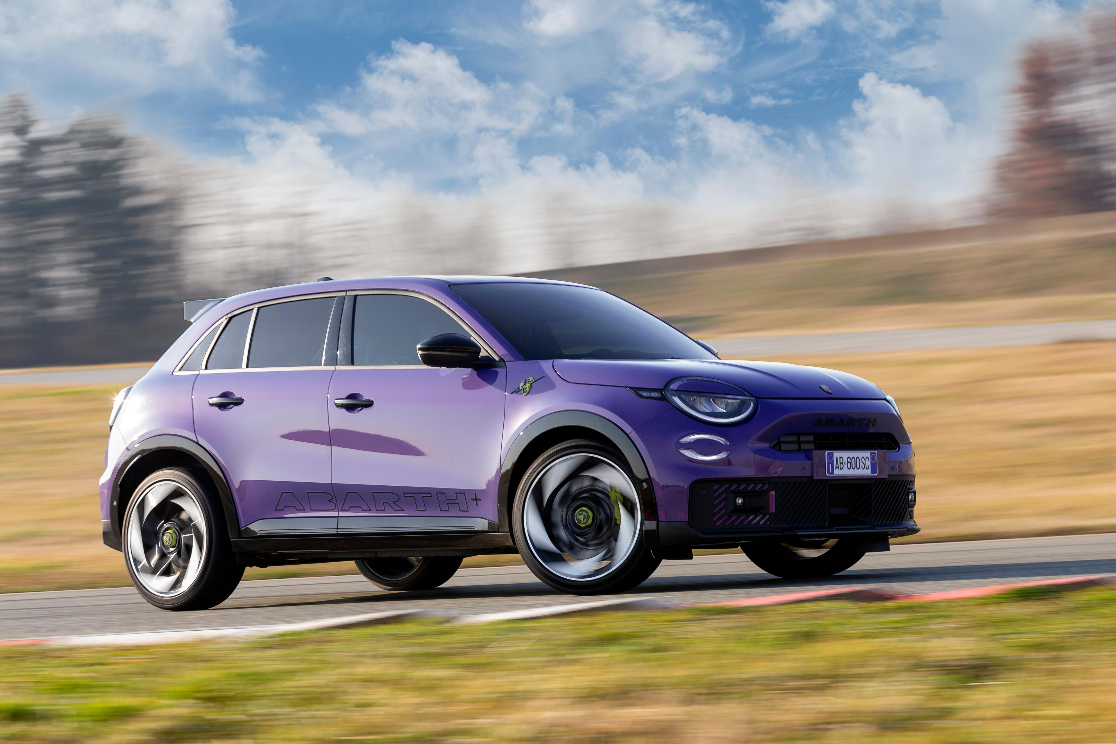 a purple abarth 600e driving on a race track