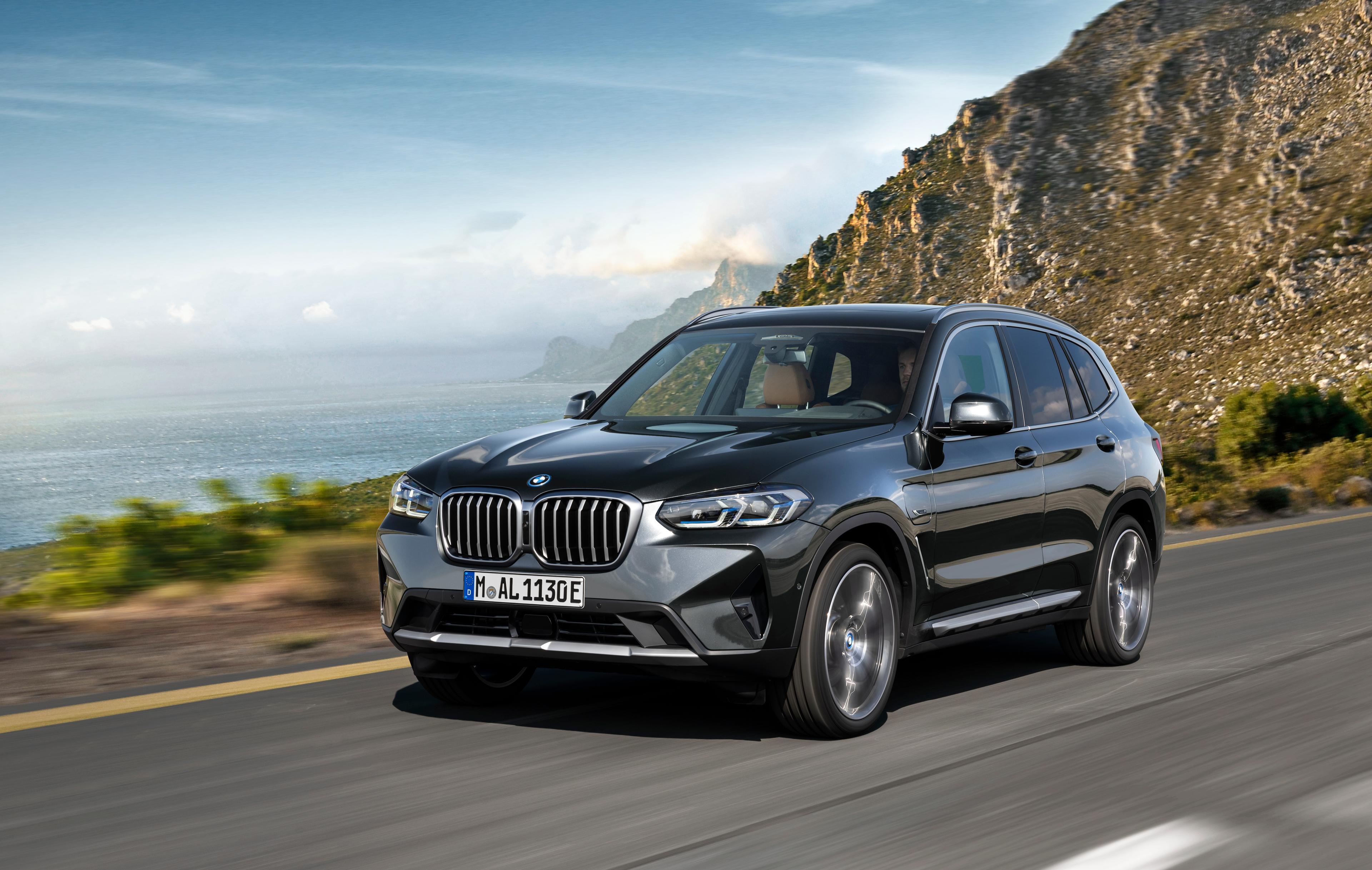 A dark coloured BMW X3 driving near a cliffside