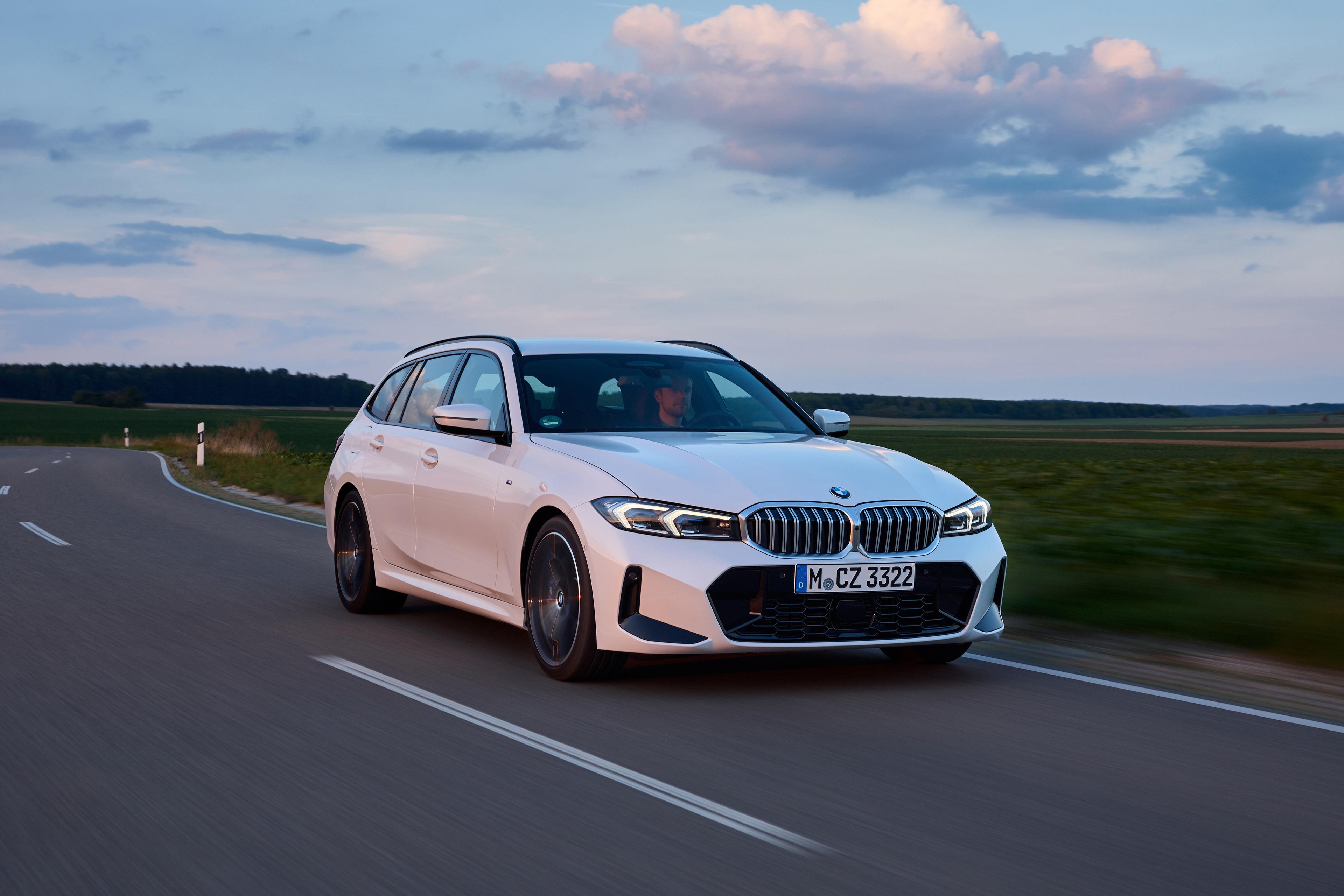 a white bmw 3 series touring being driven on a road