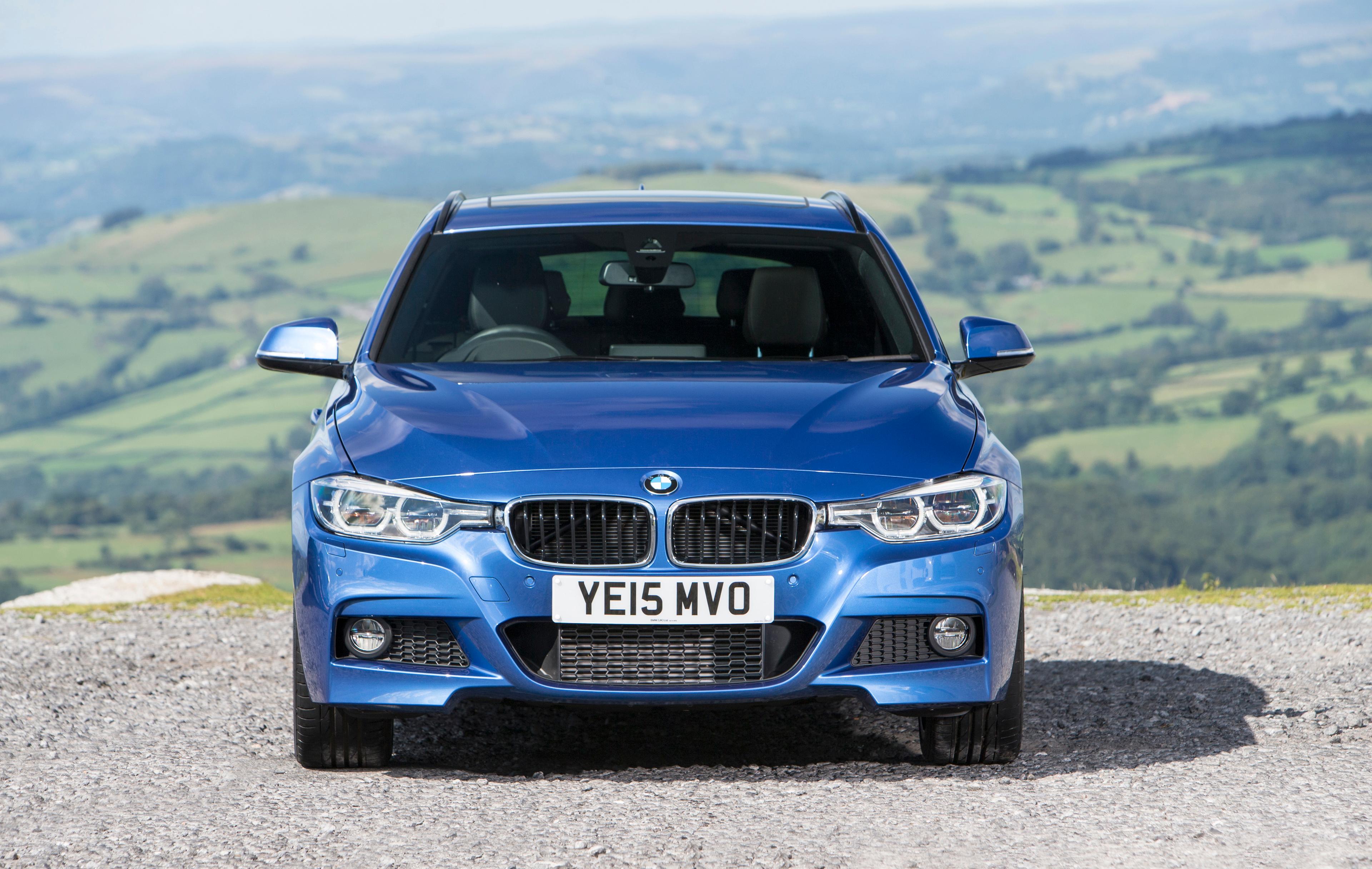 Head-on view of blue BMW 3 Series in the countryside