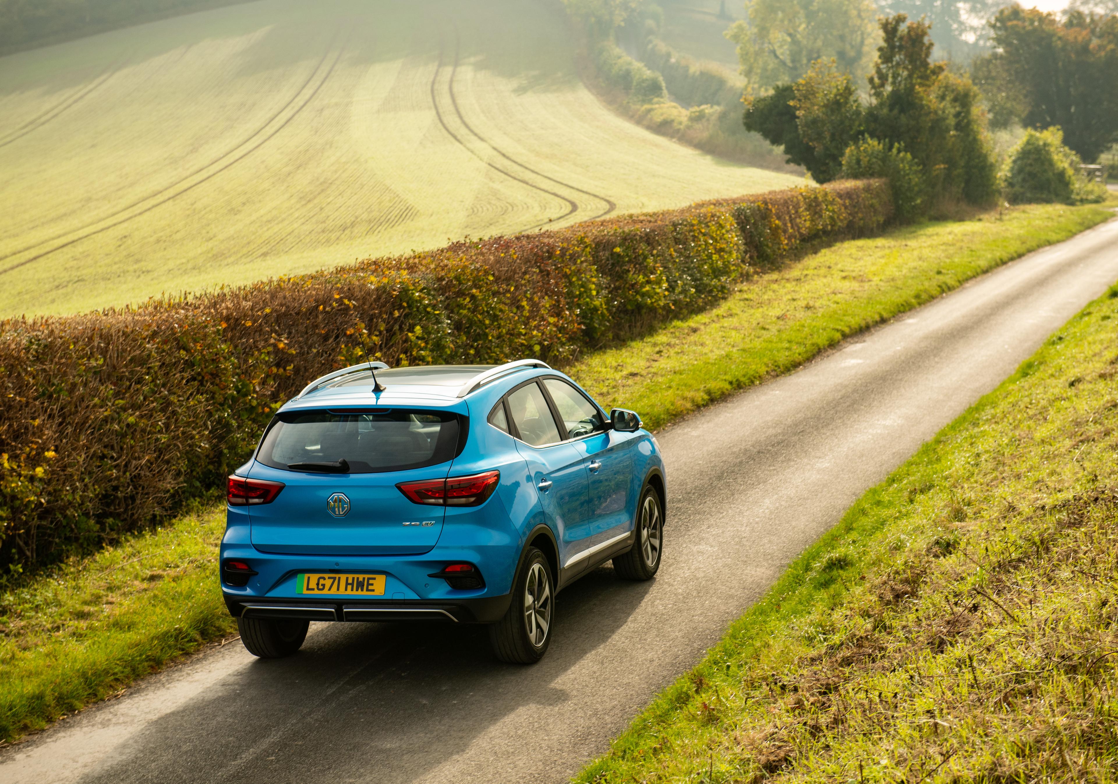 a blue MG ZS EV driving on a country road