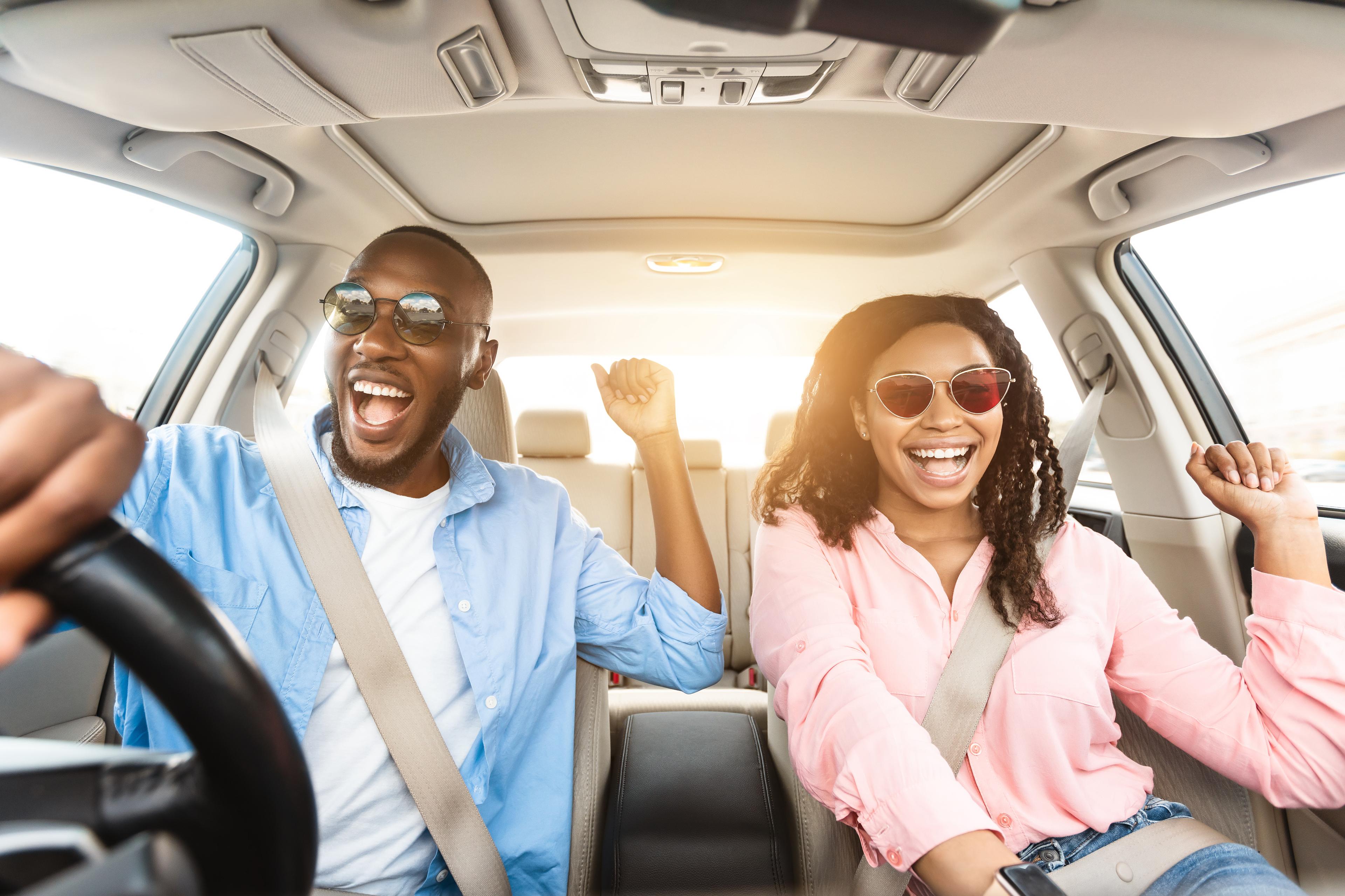 two people celebrating while driving in a car