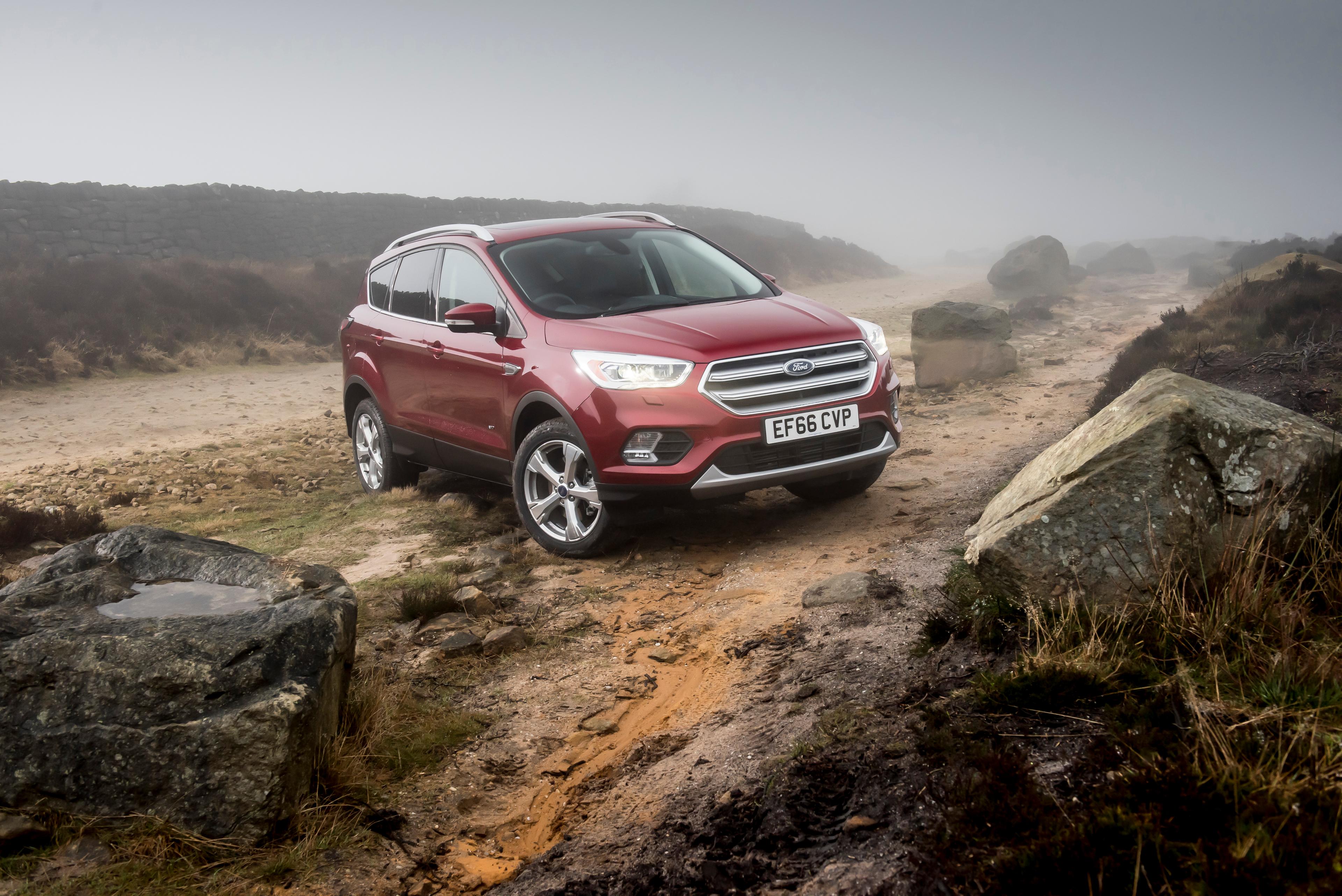 A red Ford Kuga model parked on a mountain