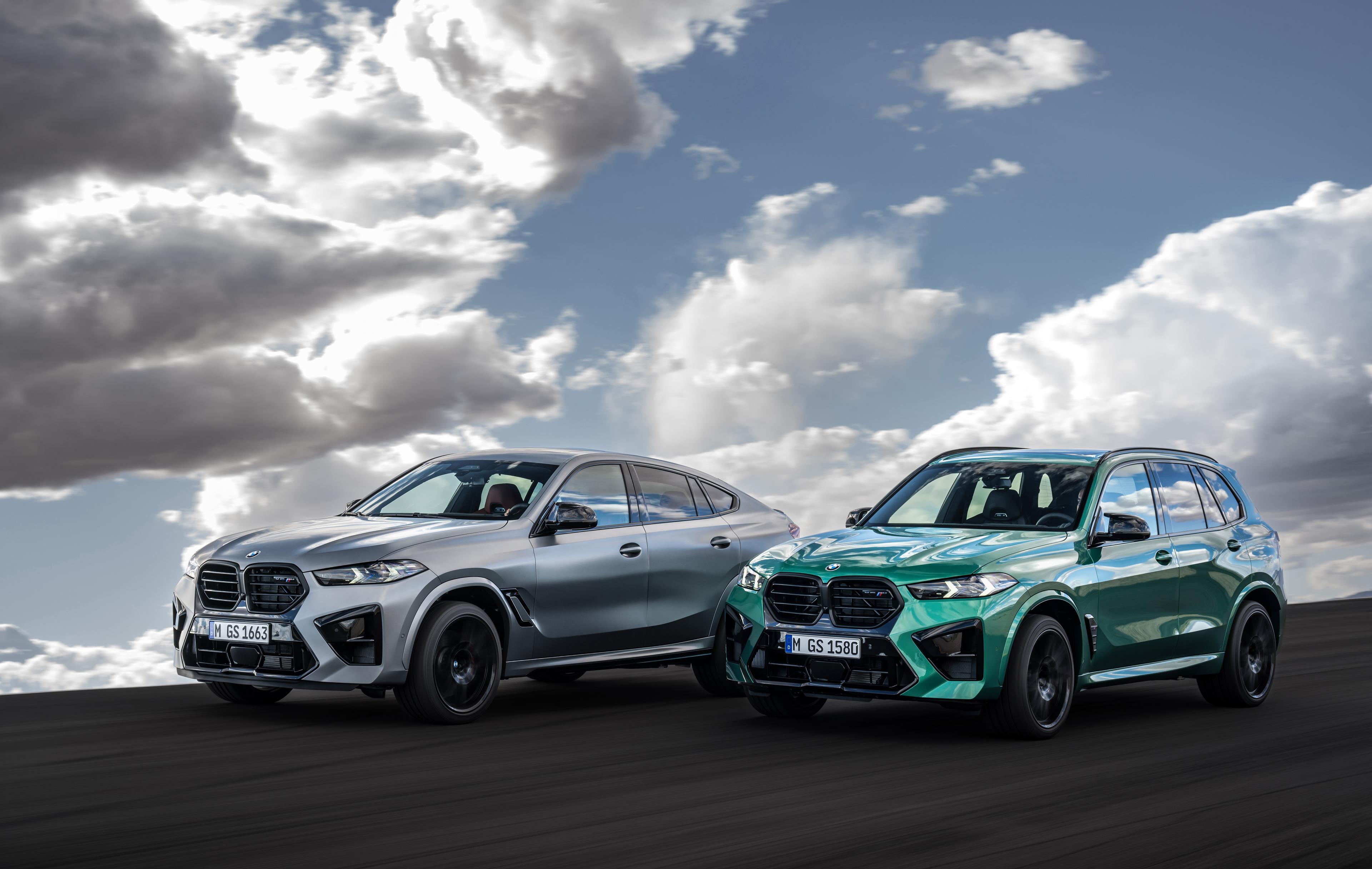 Side-by-side view of silver BMW X6 M Competition and green BMW X5 M Competition driving