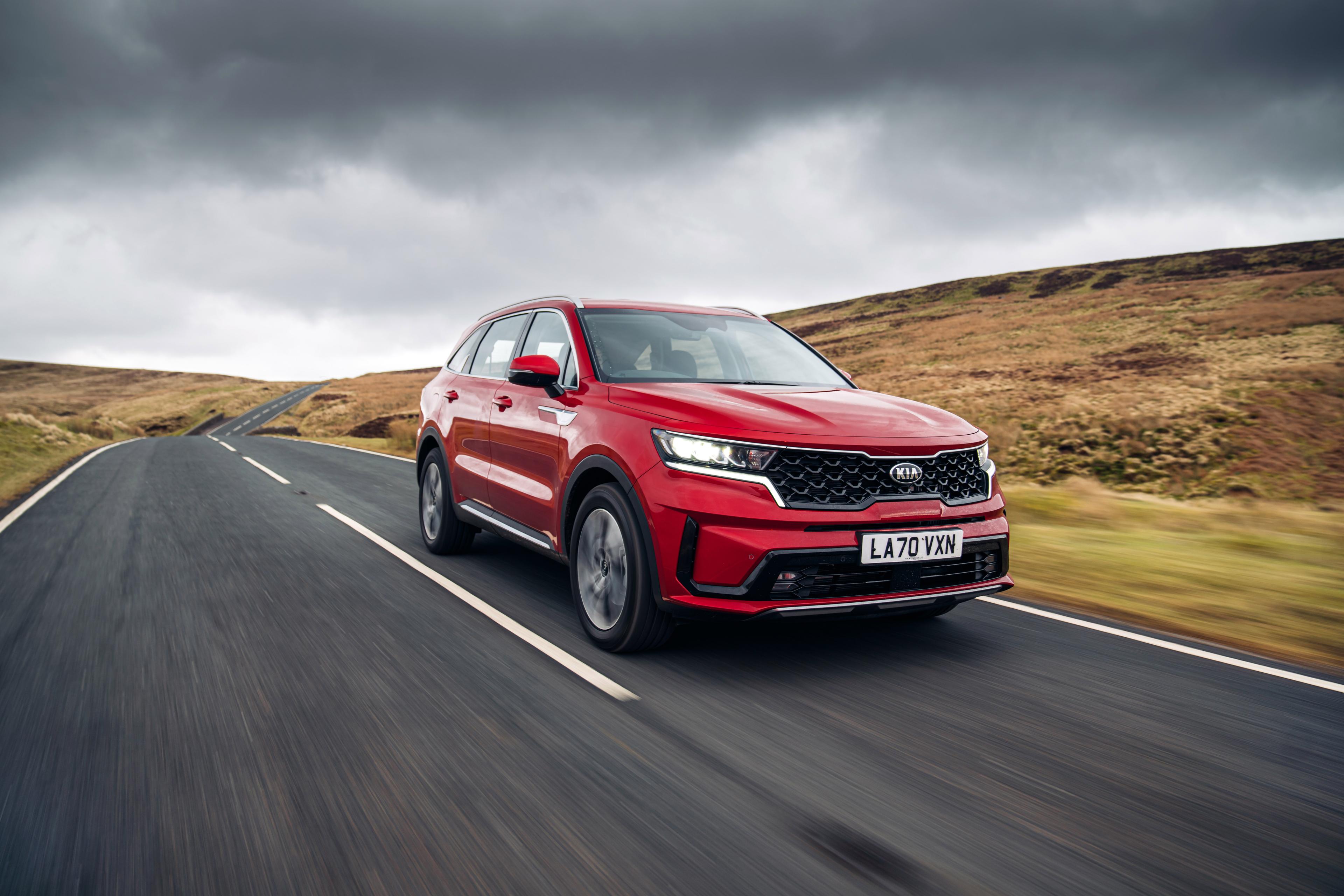 a Runway red Kia Sorento PHEV driving on a road