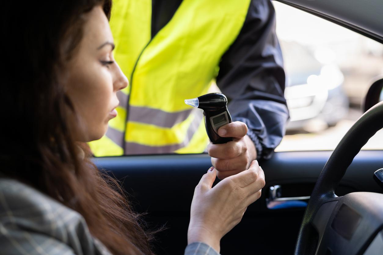 A woman being breathalysed inside a car