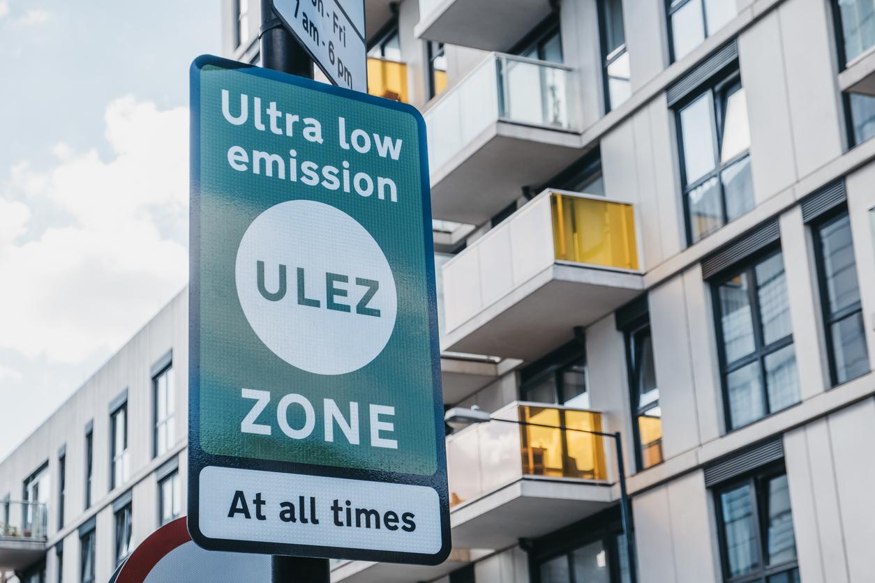 A green ULEZ sign outside of a block of flats