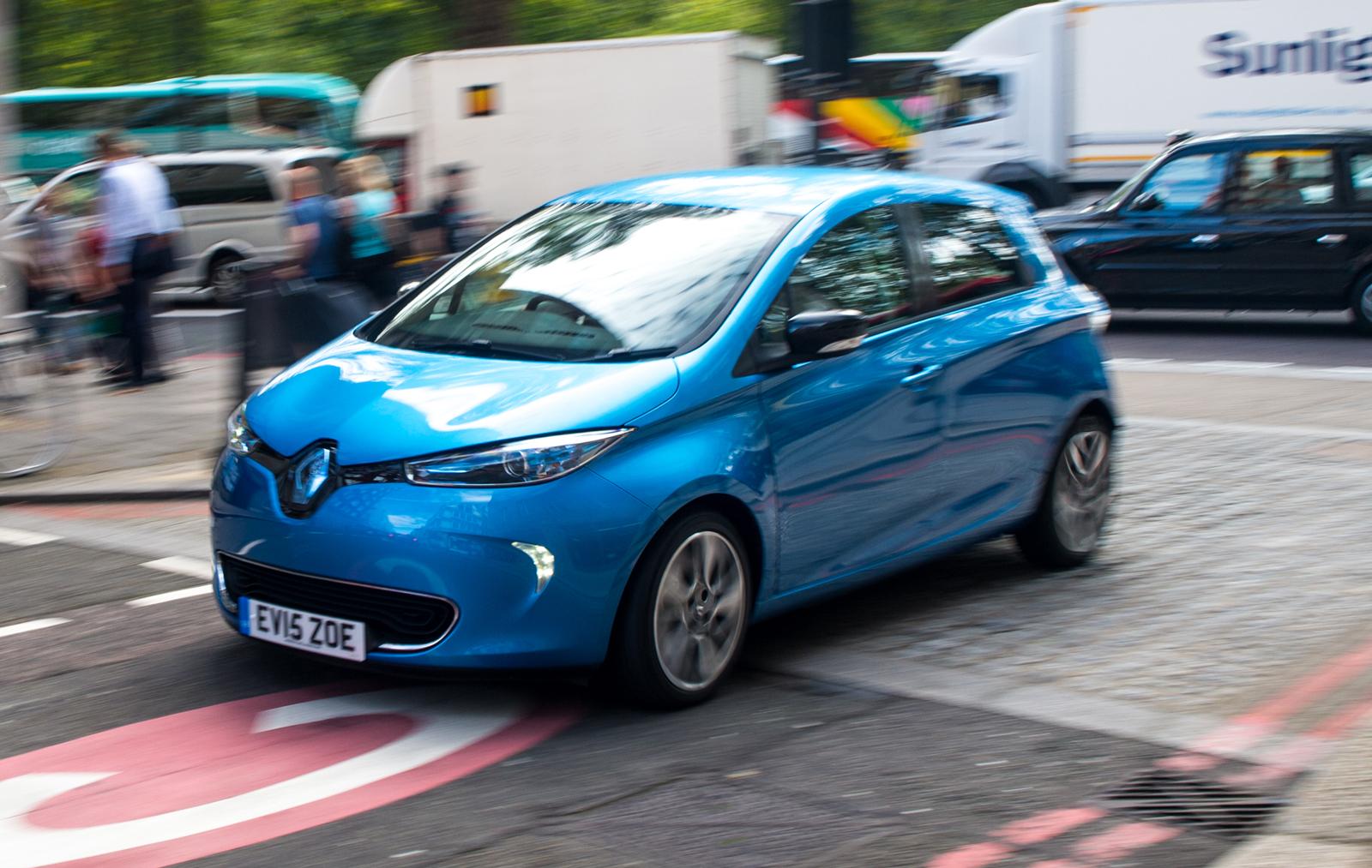a blue renault zoe driving in a city