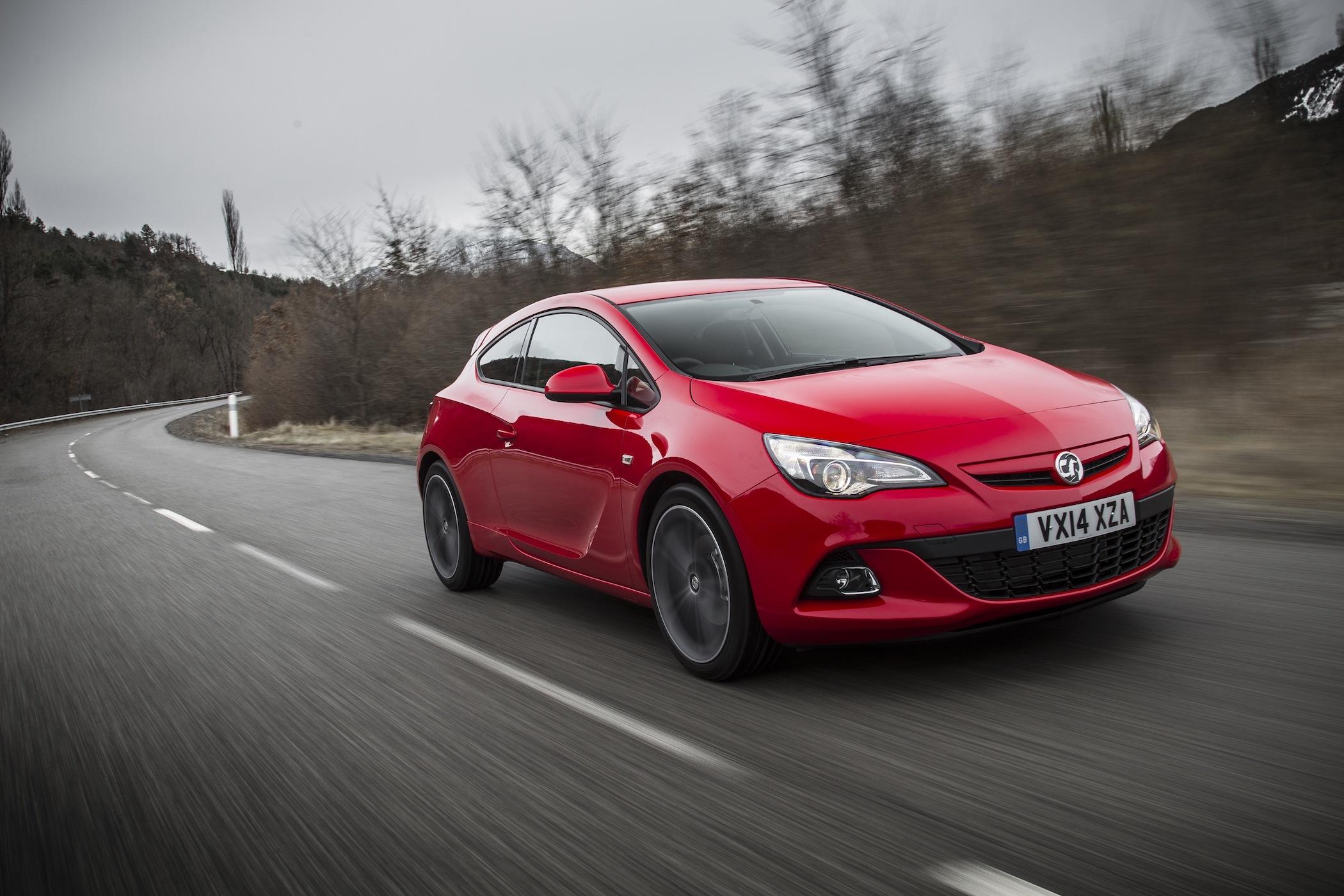 a red vauxhall astra GTC driving on a cold UK day on a country road