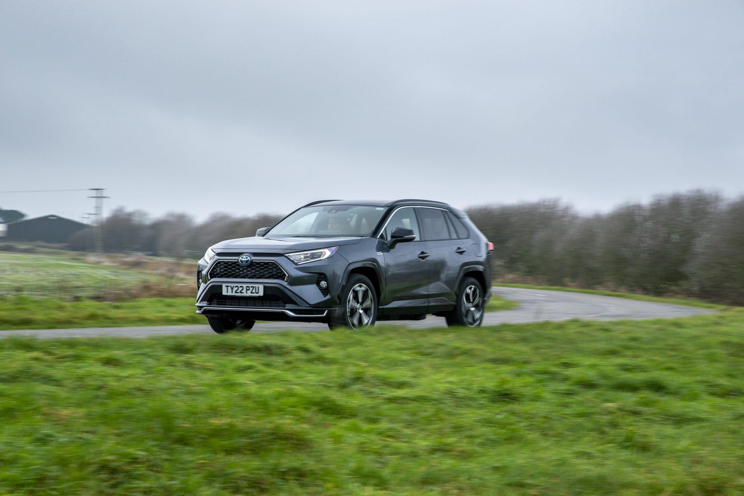 a grey Toyota RAV4 PHEV driving on a country road in the UK