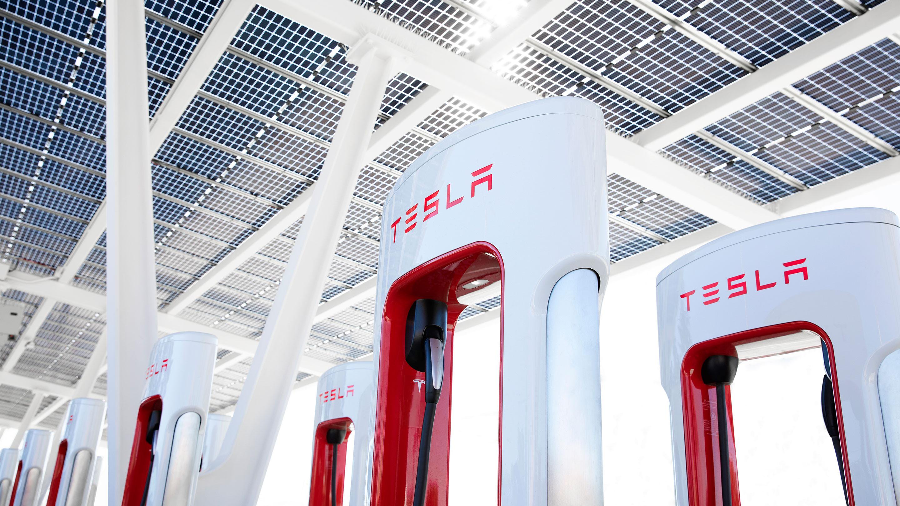red and white tesla superchargers at a station