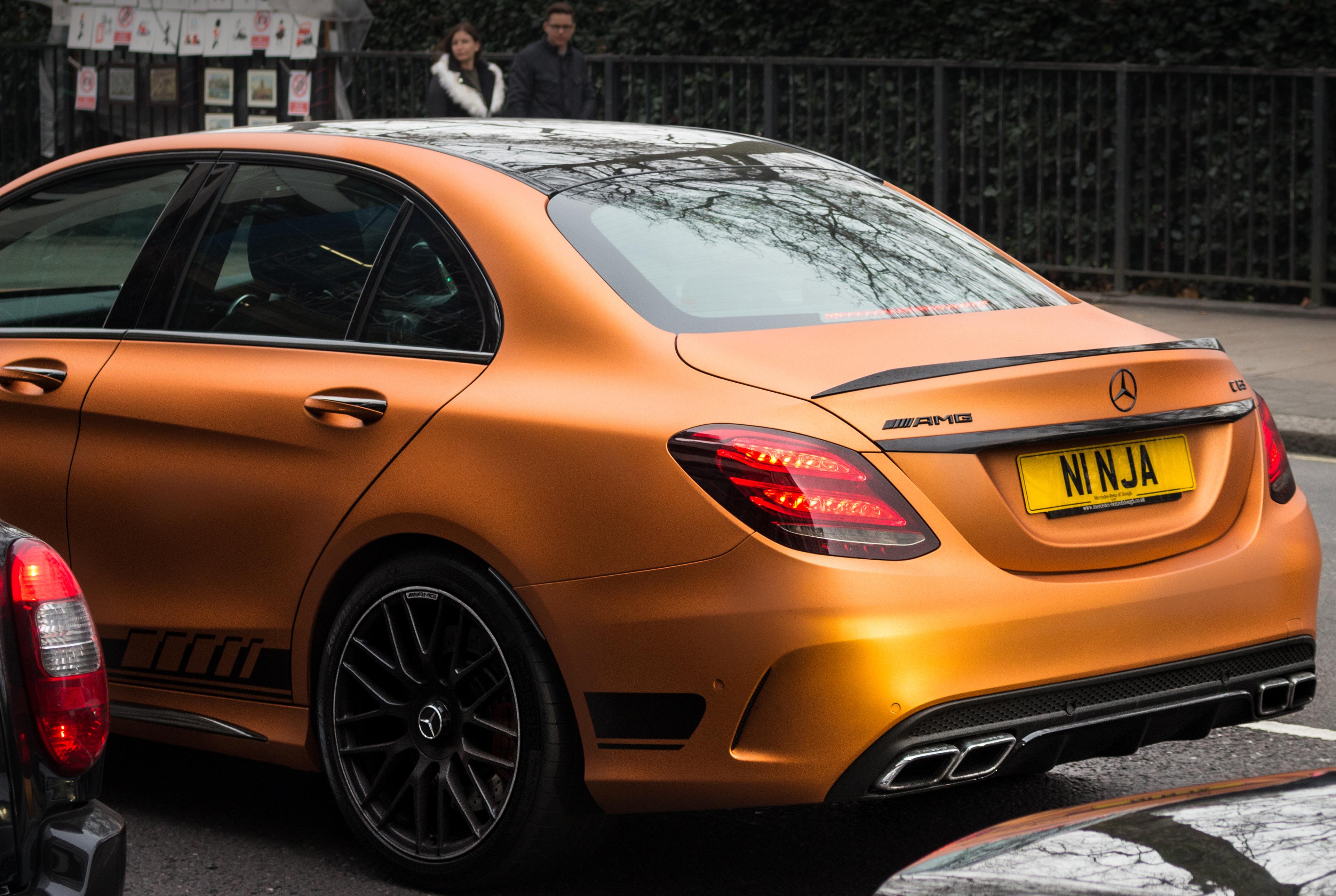 A close up of an orange Mercedes with a personalised number plate 