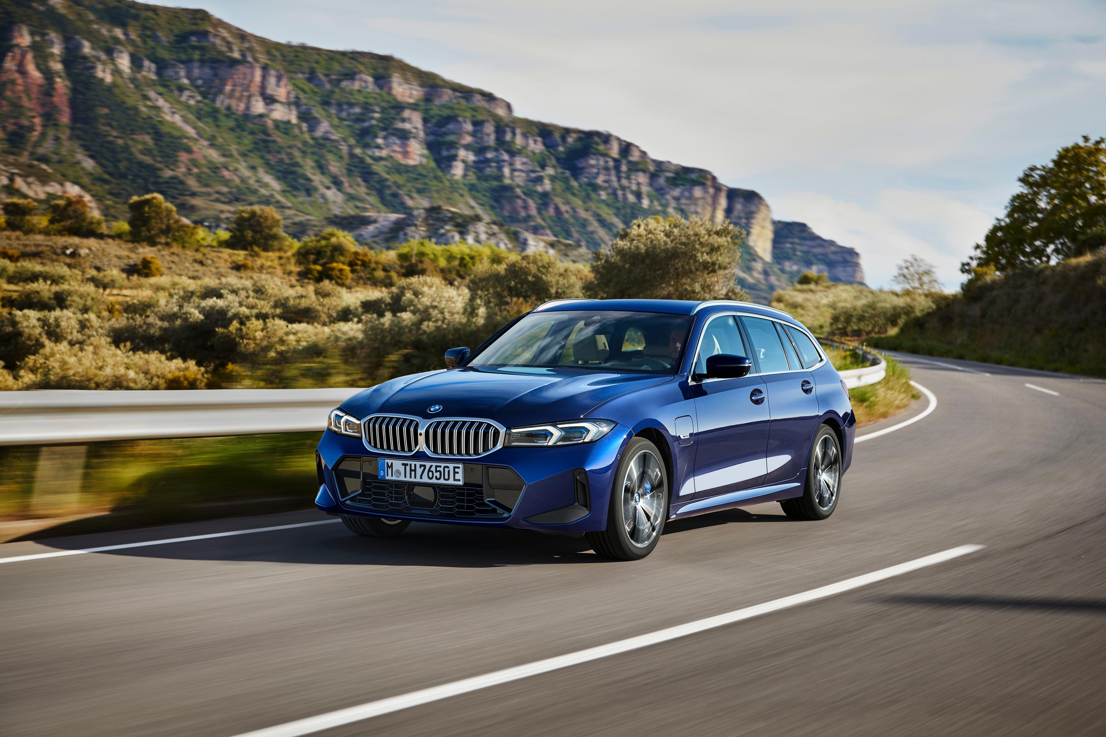 a blue bmw 3 series touring driving on a windy road