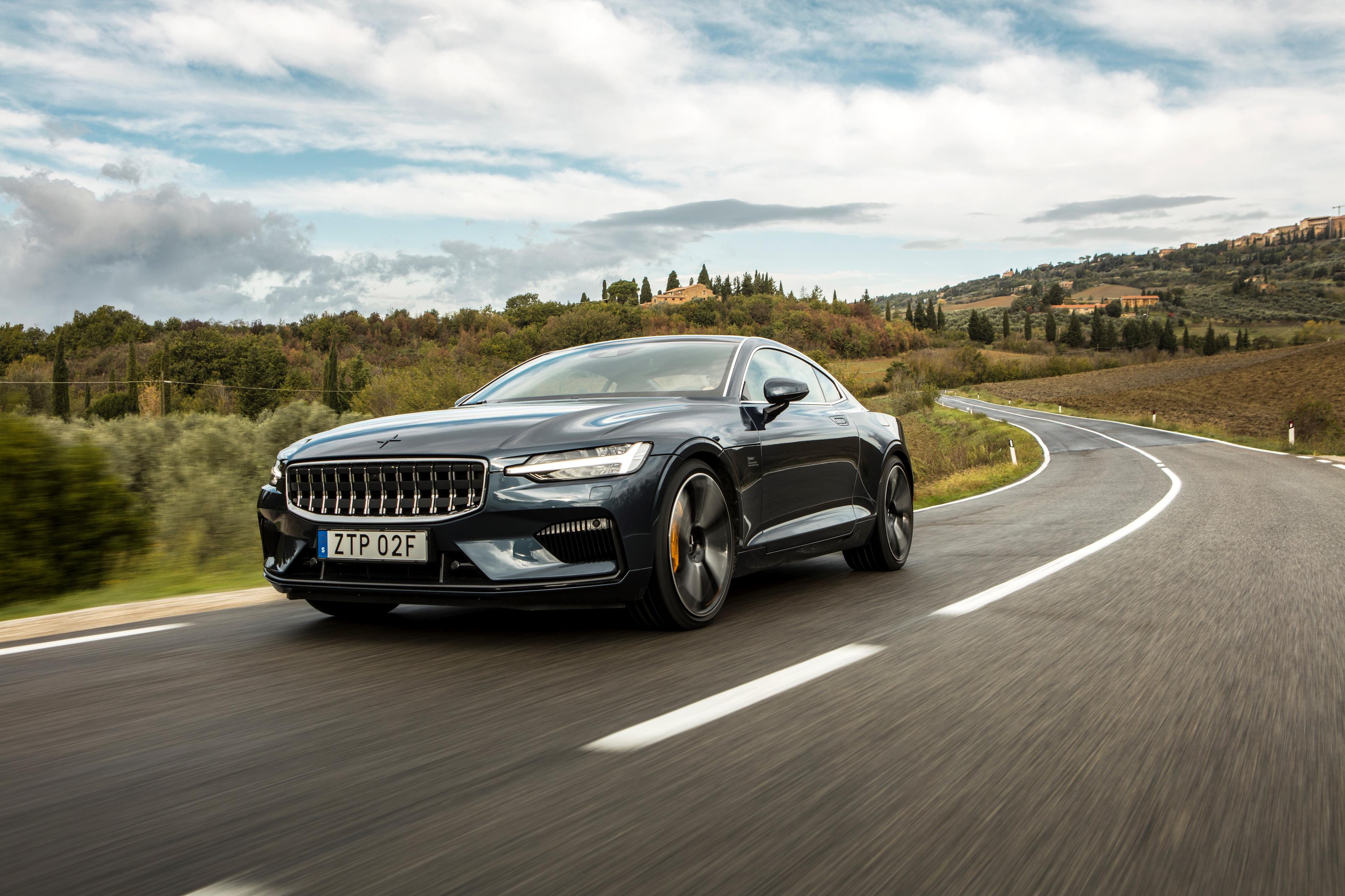 a grey polestar 1 driving on a countryside road